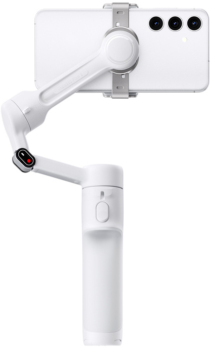 Egy fehér okostelefon egy fehér gimbal stabilizátorhoz van rögzítve. A telefonnak három kamerája van. A stabilizátornak van fogantyúja és több ízülete.
