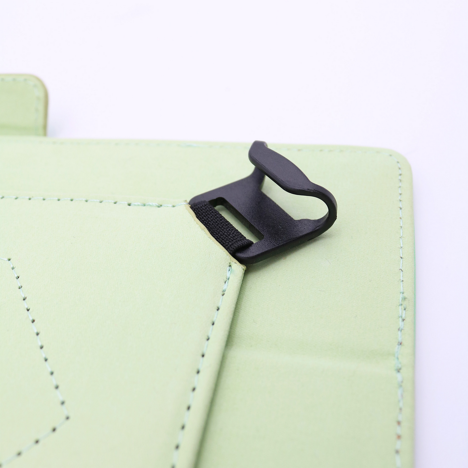 Primer plano de una funda de tableta verde claro con un cierre negro. La funda está abierta, mostrando el interior. Fondo blanco.