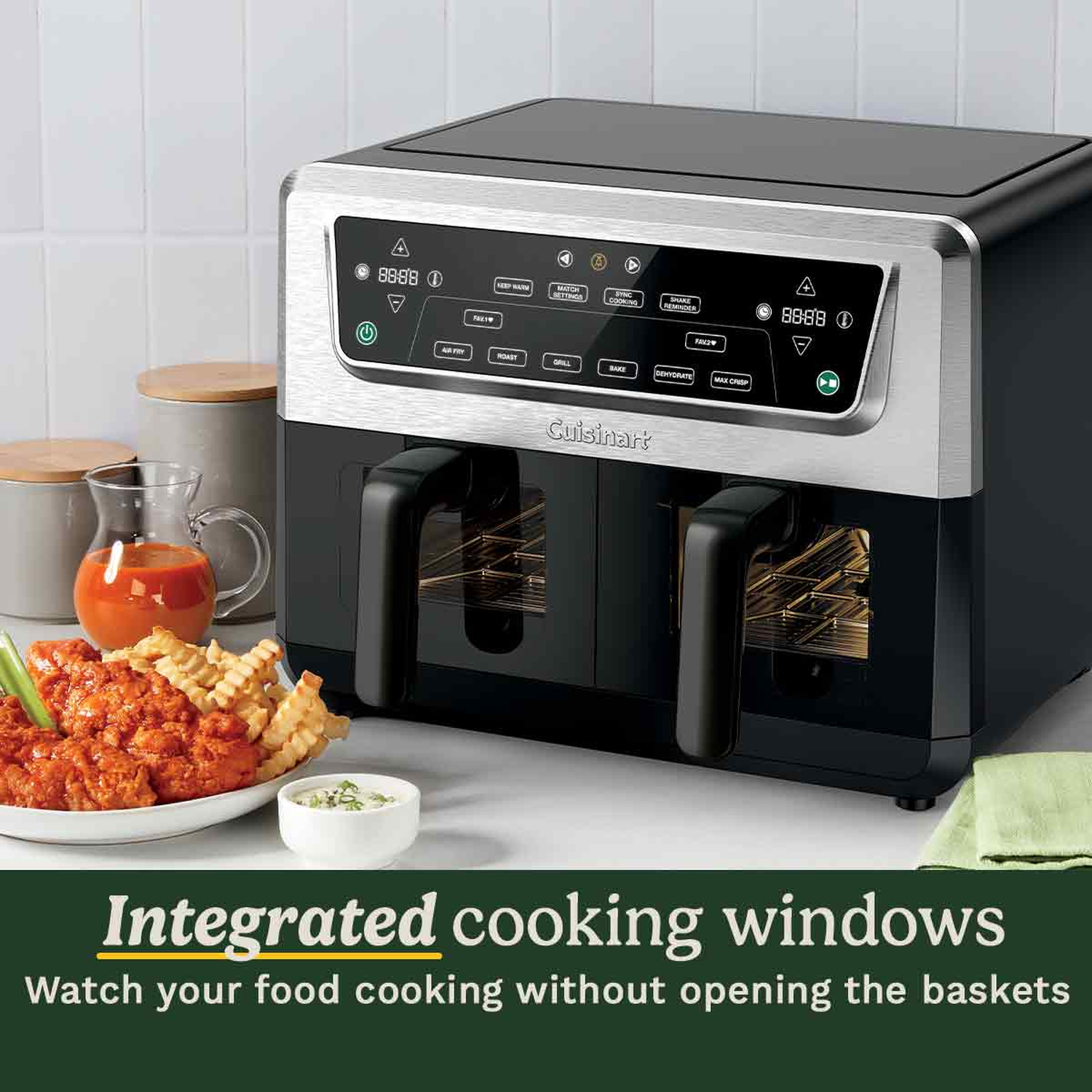 An air fryer with integrated cooking windows. A plate of food is on the left. A green towel is on the right.