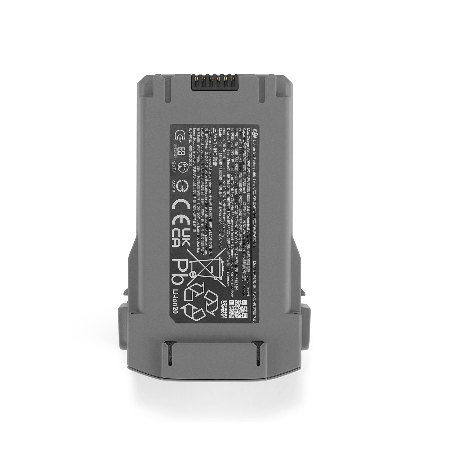 A gray DJI drone battery, with text and symbols. It is on a white surface. The battery has a black top.