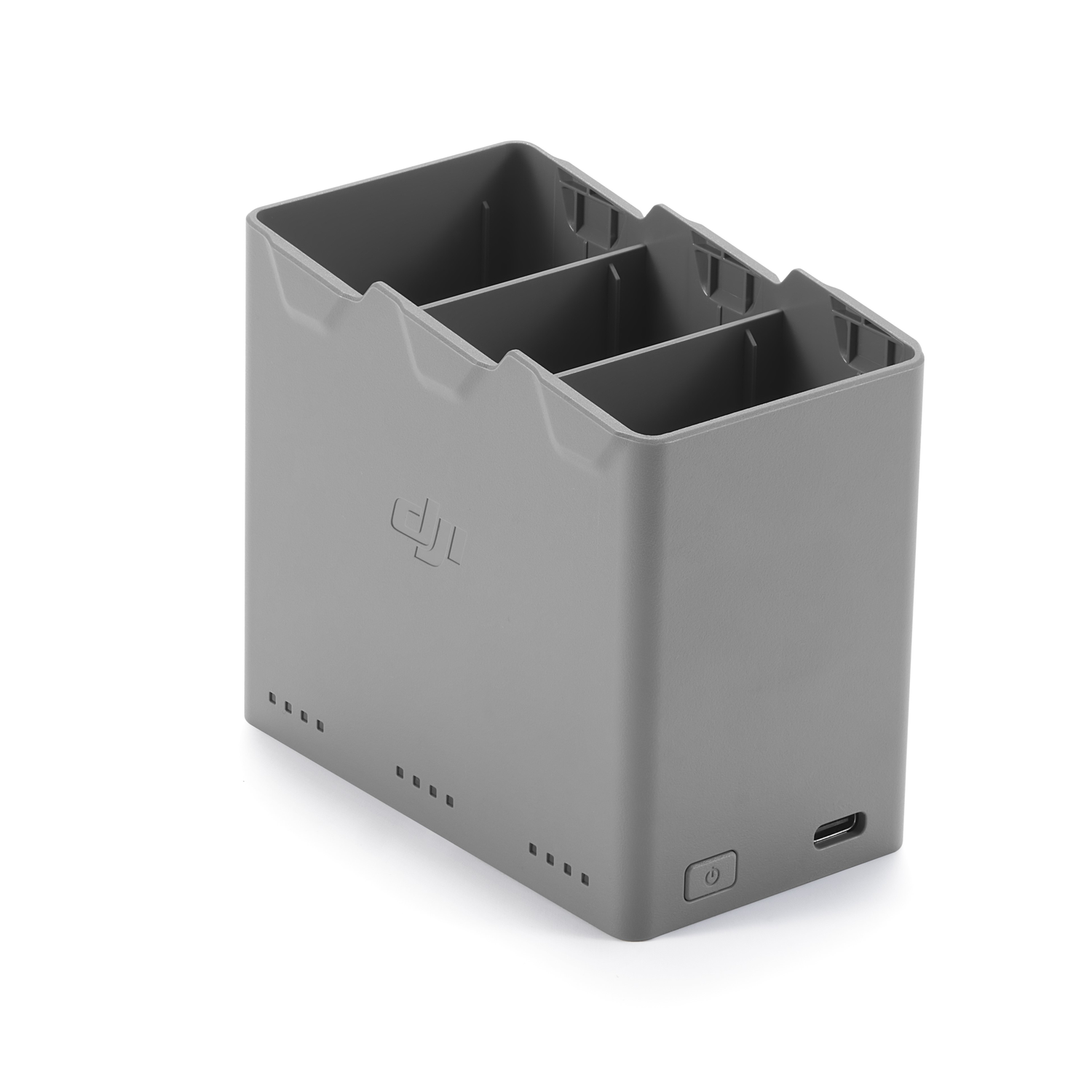 Een grijze batterijlaadstation met drie compartimenten, een aan/uit-knop en een USB-poort. De achtergrond is wit.