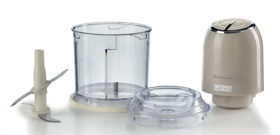 Zdemontowany robot kuchenny. Części to ostrza, przezroczysta miska, pokrywa i beżowa podstawa silnika.