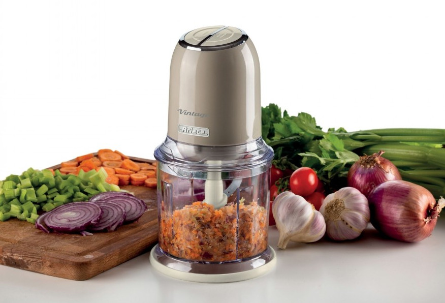 Robot kuchenny z posiekanymi warzywami i składnikami takimi jak cebula, czosnek, pomidory i seler.