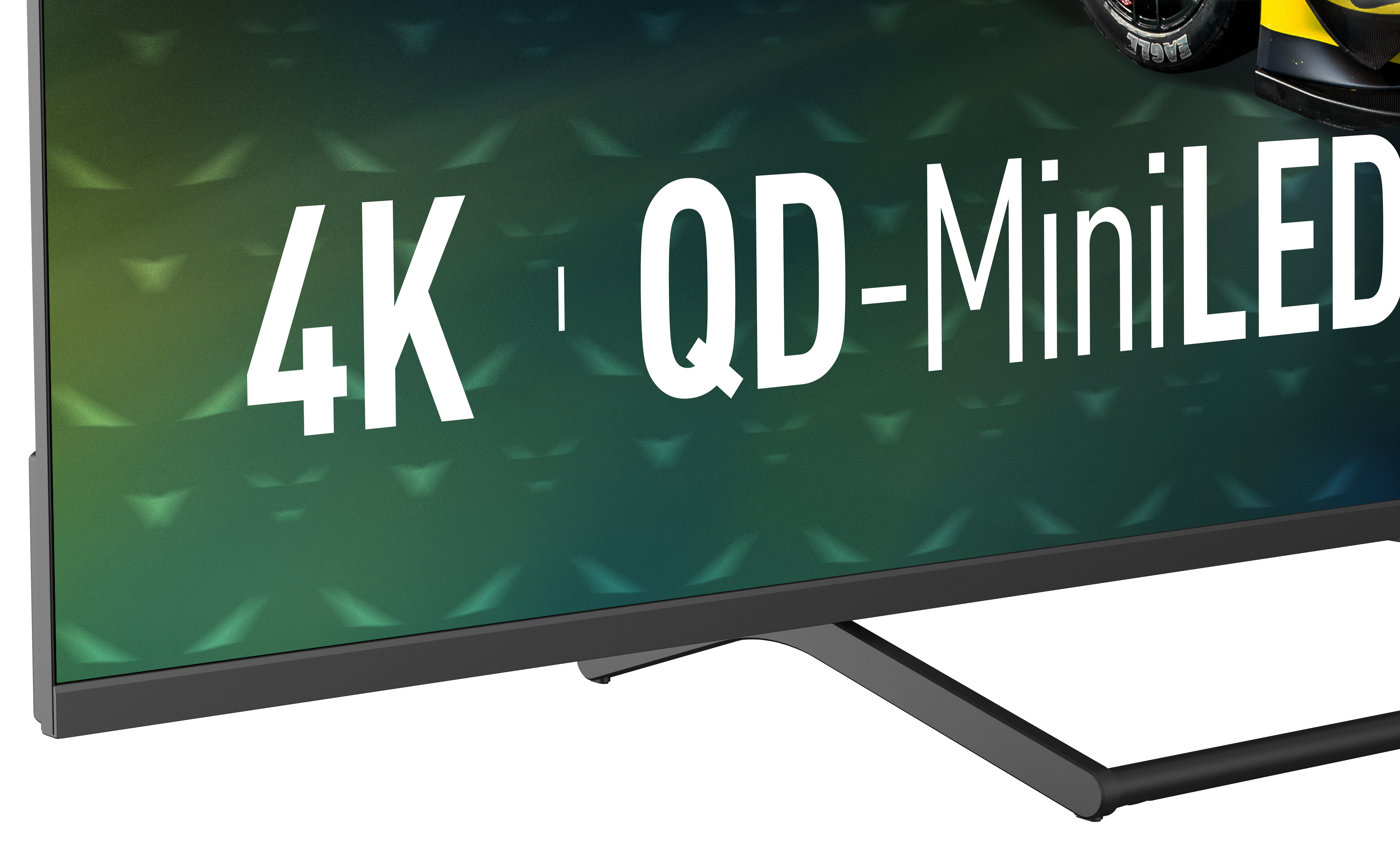Ekran telewizora z tekstem 4K, QD-MiniLED. Koło samochodu jest częściowo widoczne w prawym górnym rogu. Ekran ma podstawę.
