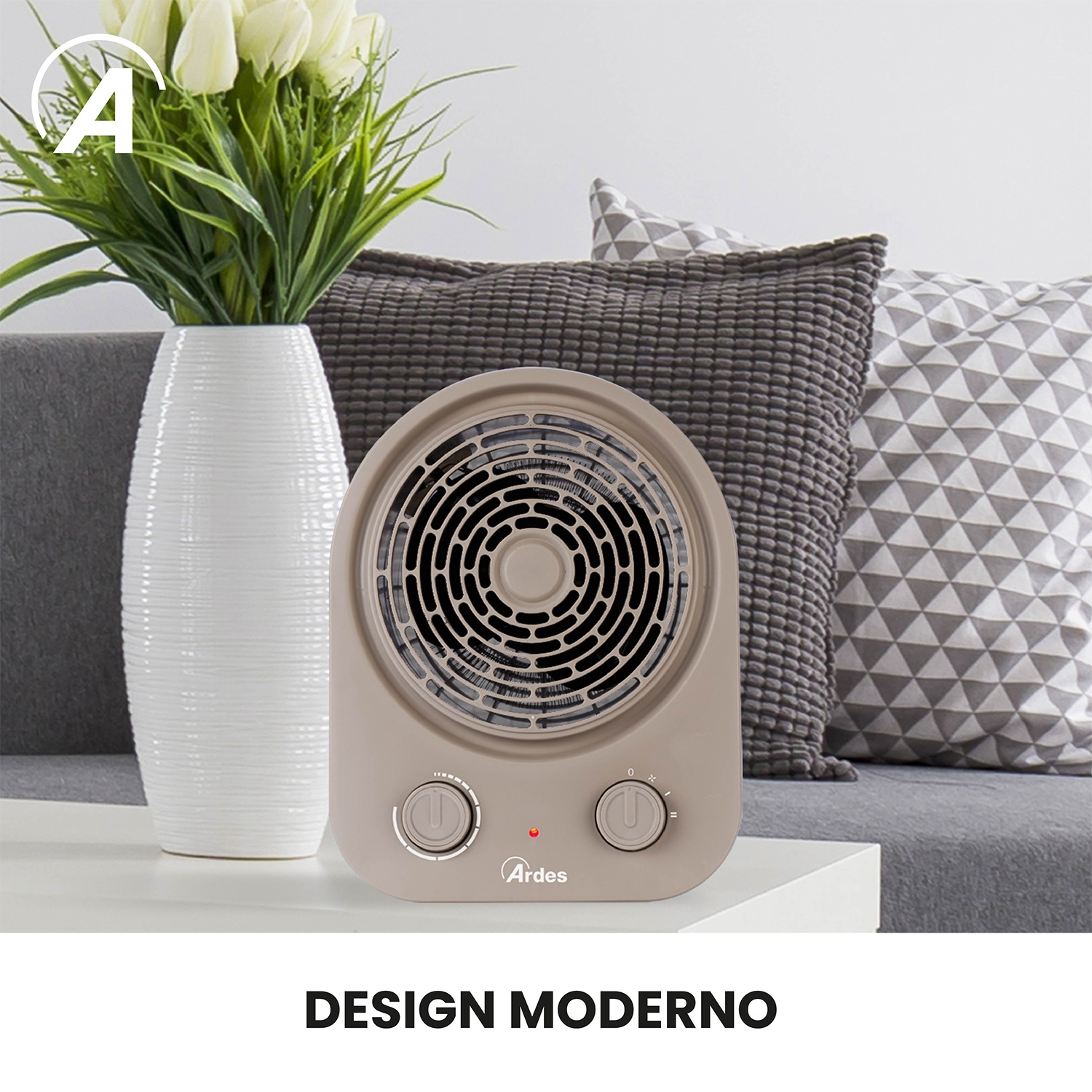 Termoventilatore beige su un tavolo bianco, con vaso bianco di fiori e cuscini decorativi dietro. Il termoventilatore ha due manopole.