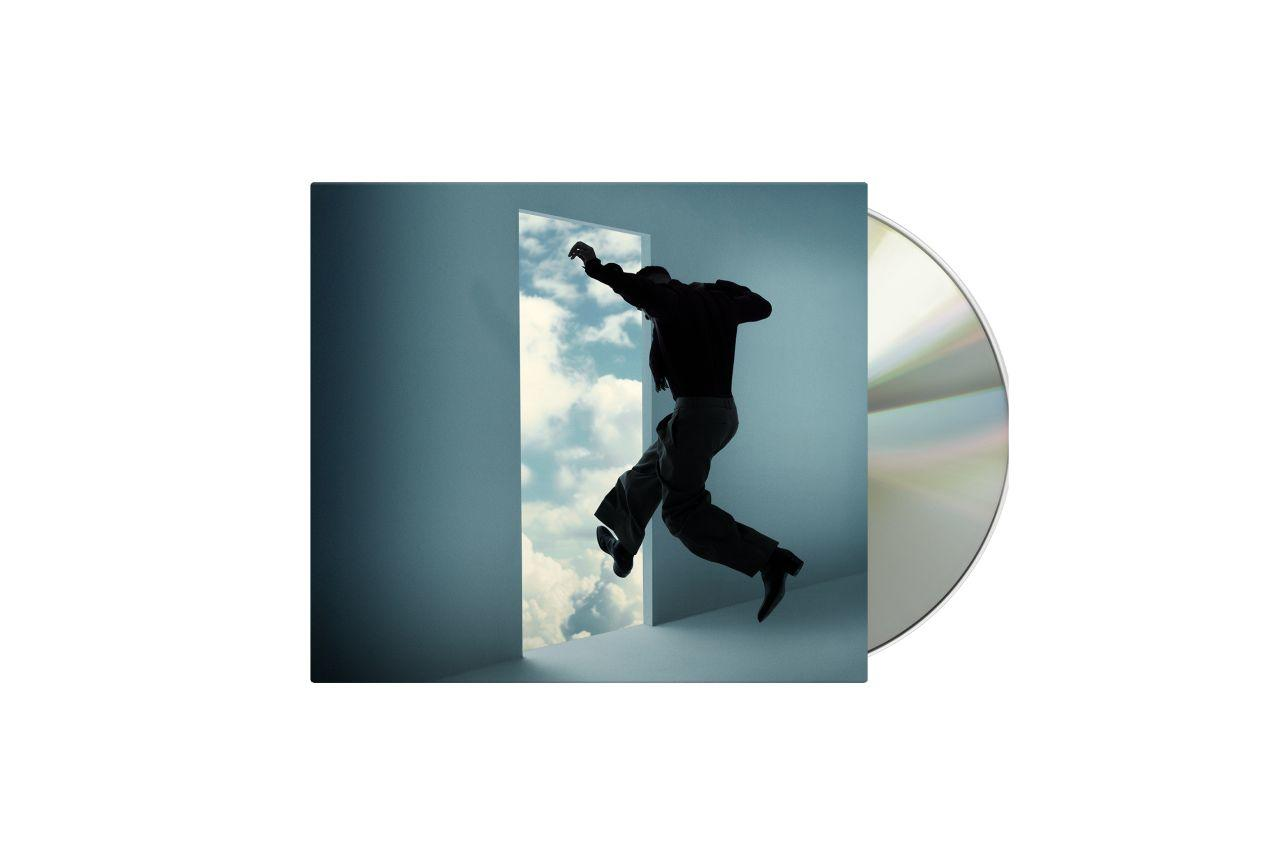 Mann springt durch Tür in blauen Himmel, daneben eine CD.