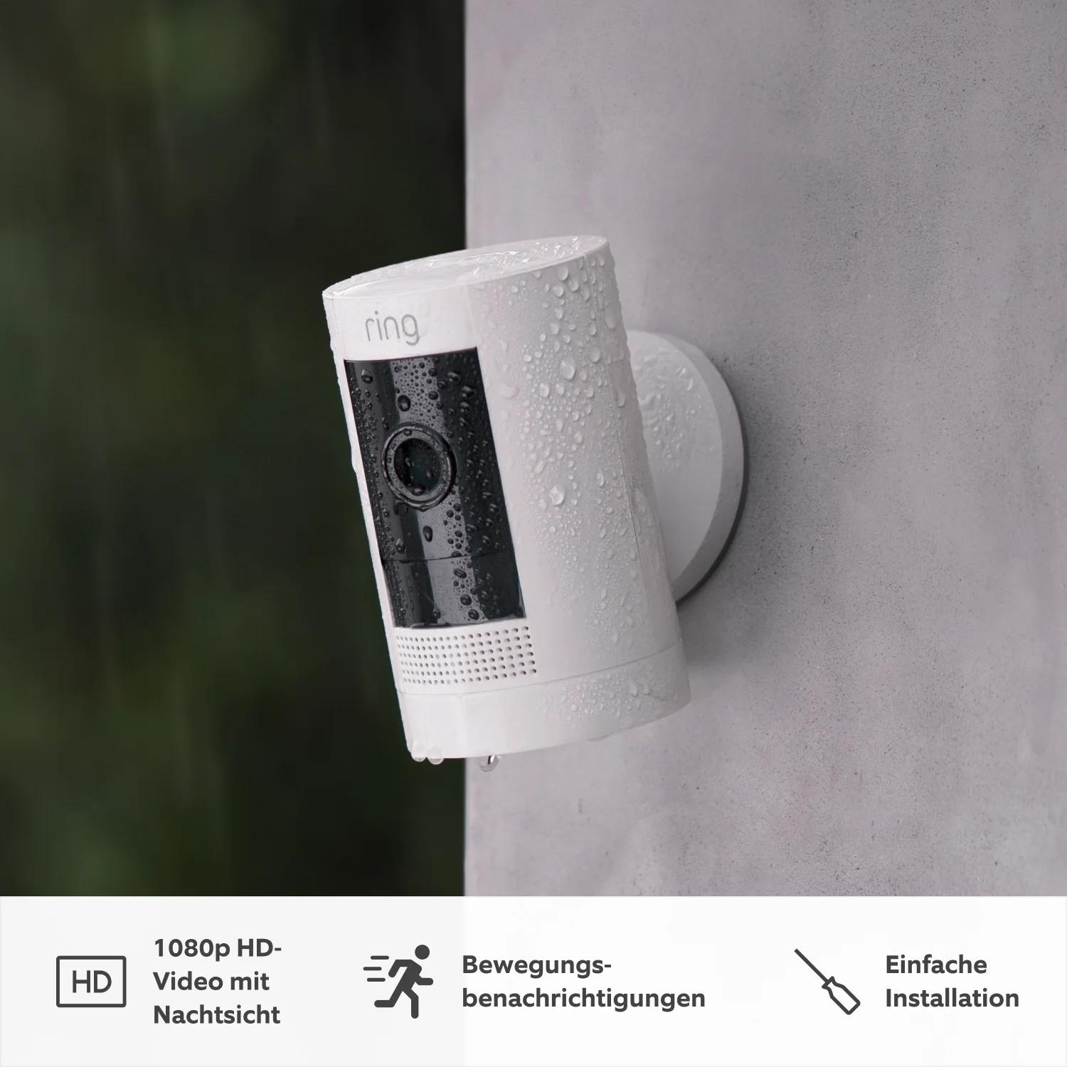 Weiße Ring-Überwachungskamera an der Wand. Die Kamera hat eine schwarze Vorderseite und ist nass. Text sagt HD-Video, Bewegungserkennung, einfache Installation.