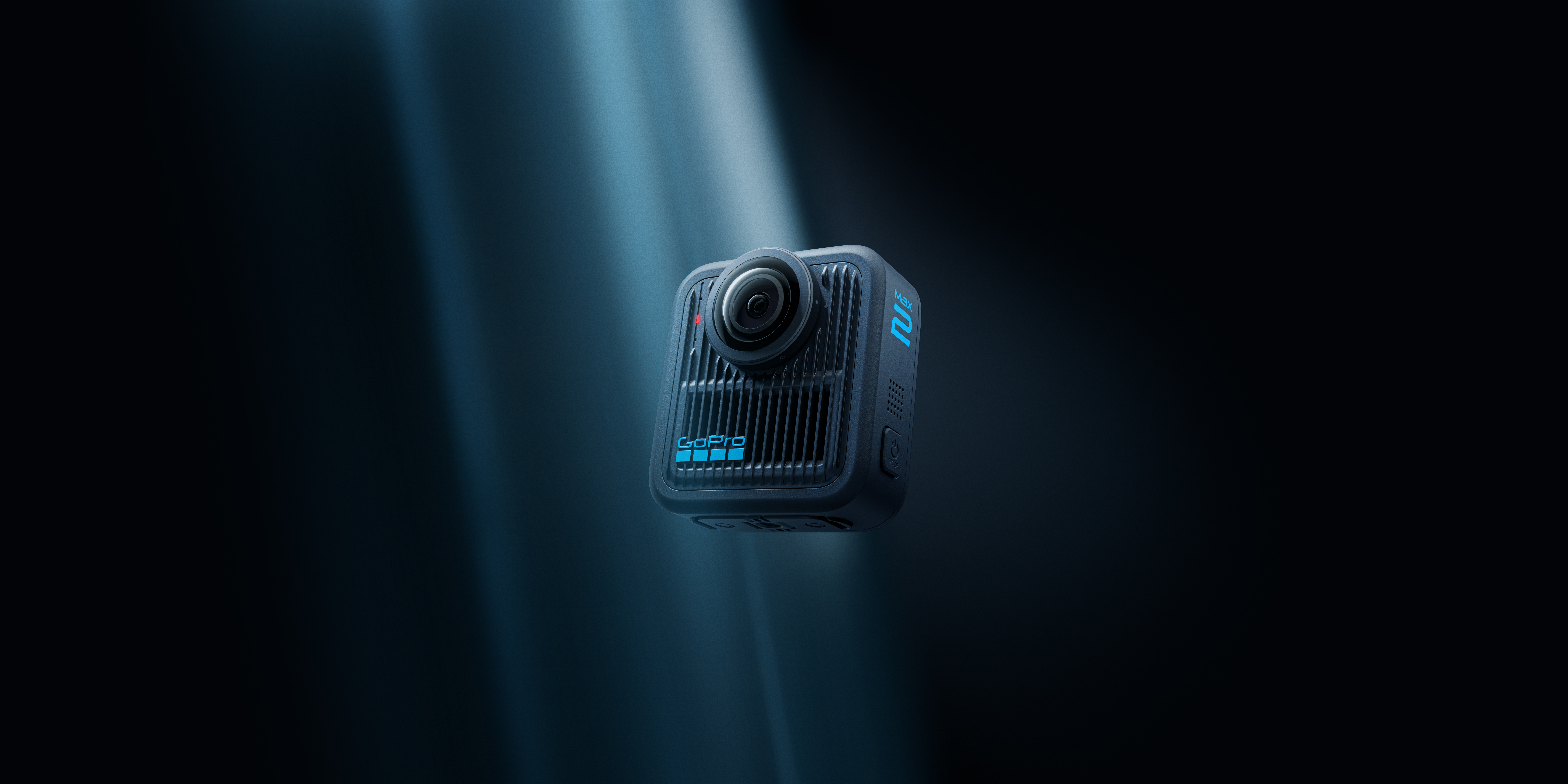 Eine GoPro Max 2 Kamera schwebt in einem dunkelblauen Raum, beleuchtet von einem Lichtstrahl. Die Kamera hat ein Dual-Objektiv-Design.