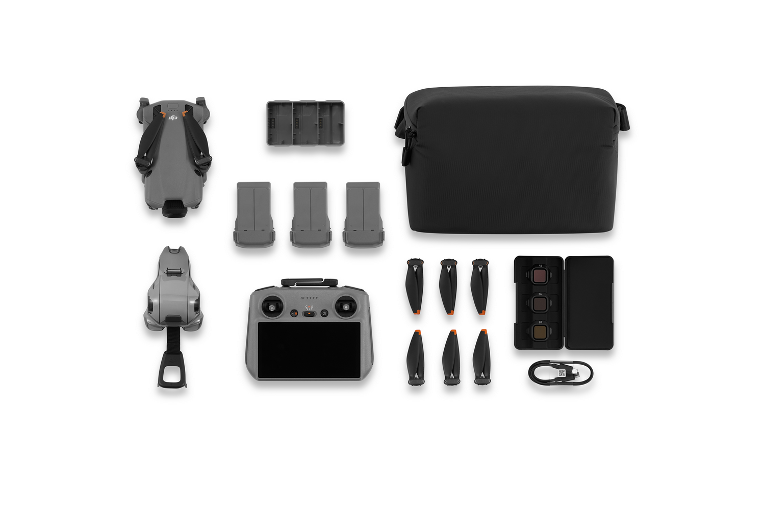Kit de drones sobre fondo blanco. Incluye dron, mando, baterías, bolsa, hélices, filtros y cable de carga.