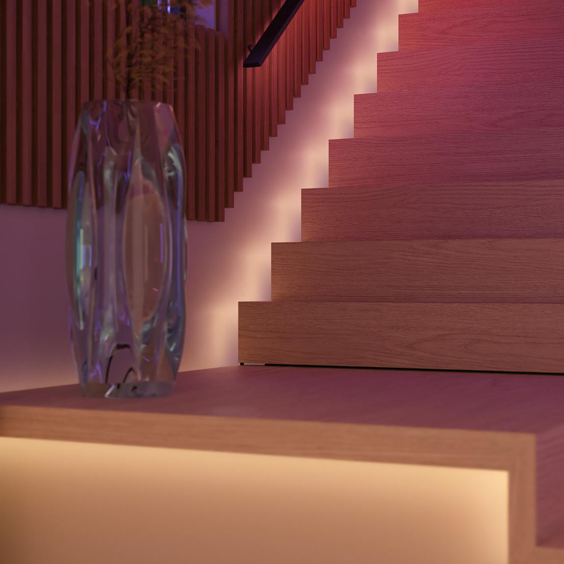 Eine Glasvase mit einer Pflanze steht auf einer Holzoberfläche. Holztreppen mit Lichtern steigen auf, und eine Holzwand ist im Hintergrund.
