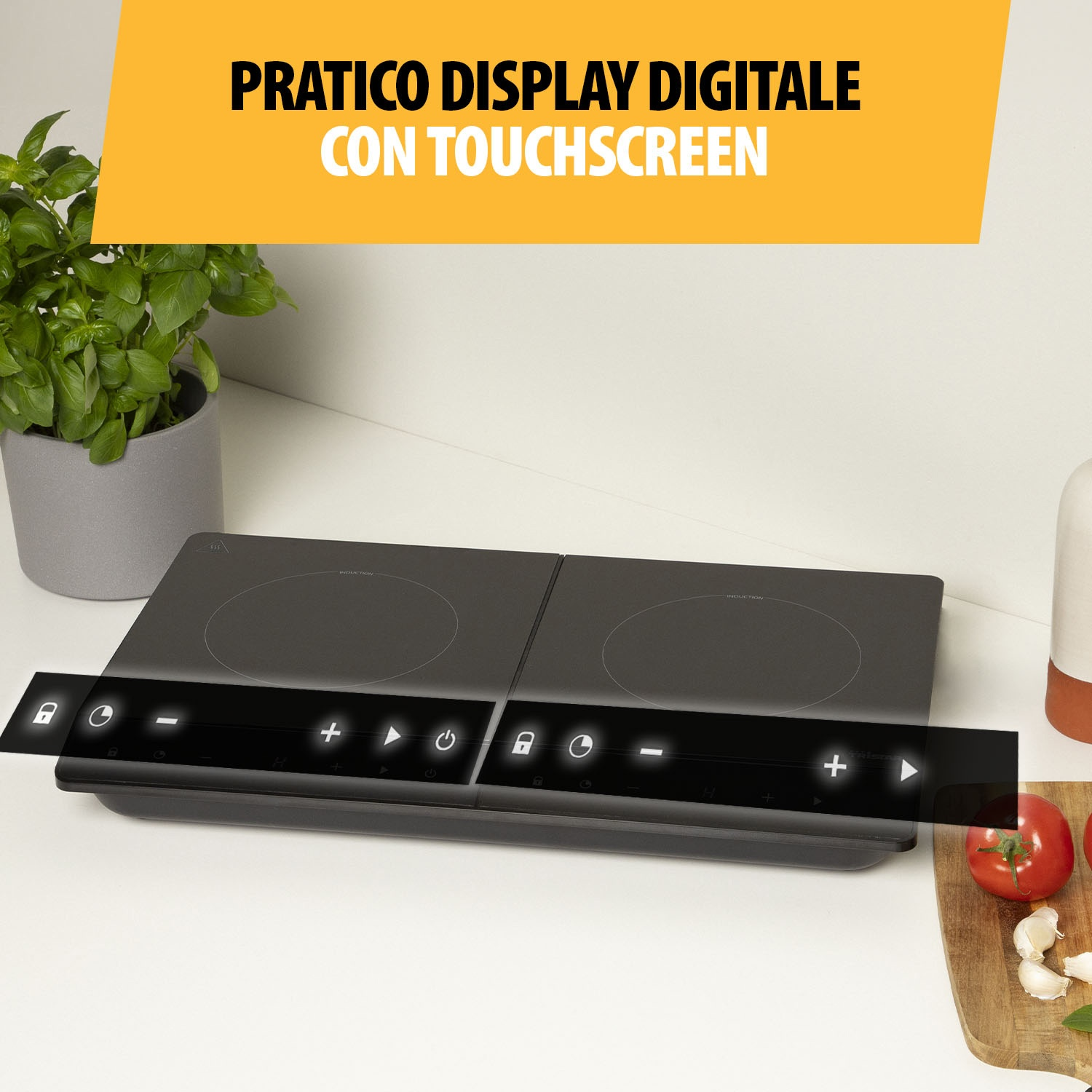 Piano cottura a induzione nero con comandi touchscreen. Un vaso di piante e ingredienti sul bancone bianco.