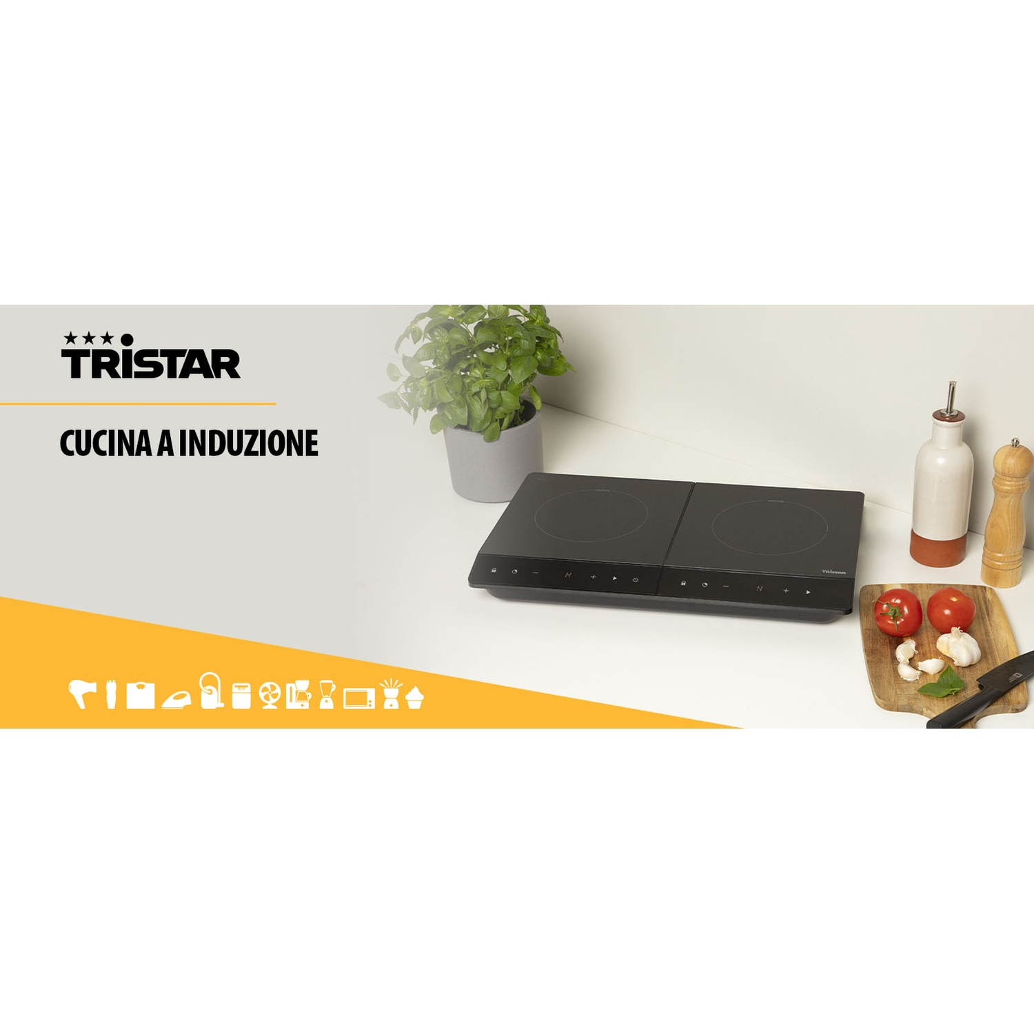 Piano cottura a induzione nero con due fuochi. Pomodori, aglio, bottiglia d'olio e una pianta accanto. Il logo Tristar è visibile.