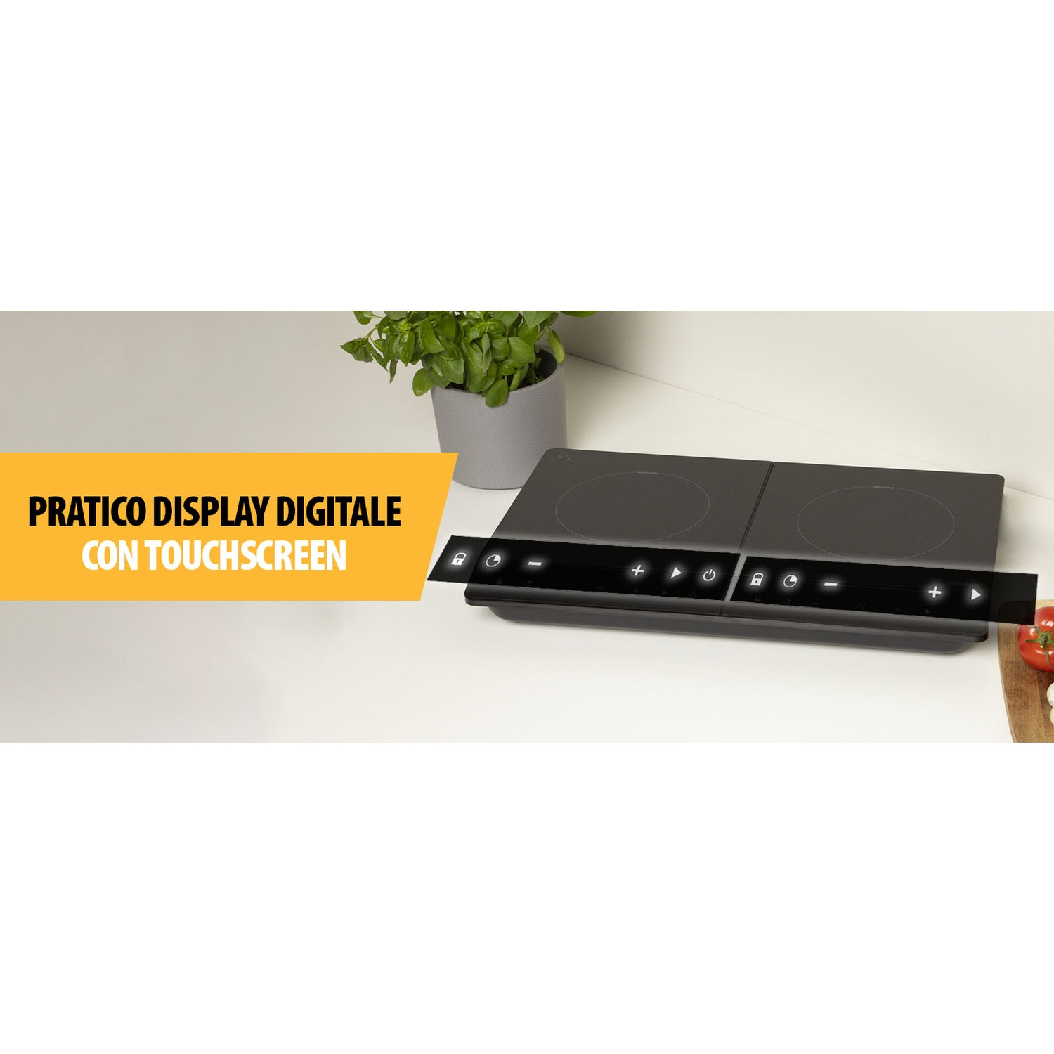 Un piano cottura a induzione nero con comandi touchscreen su una superficie bianca. Una pianta in vaso grigio vicina, verdure su un tagliere.