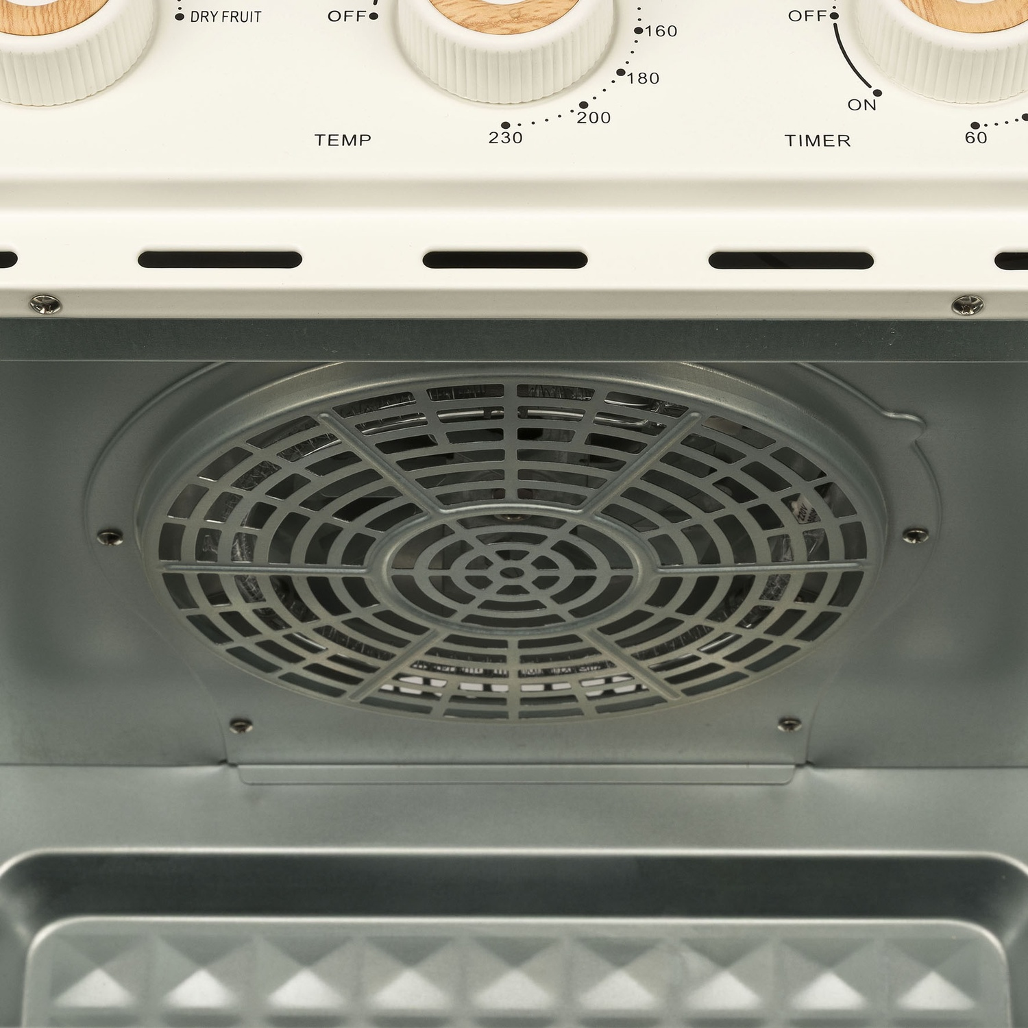 Interno di un forno. È visibile una ventola, insieme ai comandi della temperatura e del timer. Il forno è bianco e metallico.