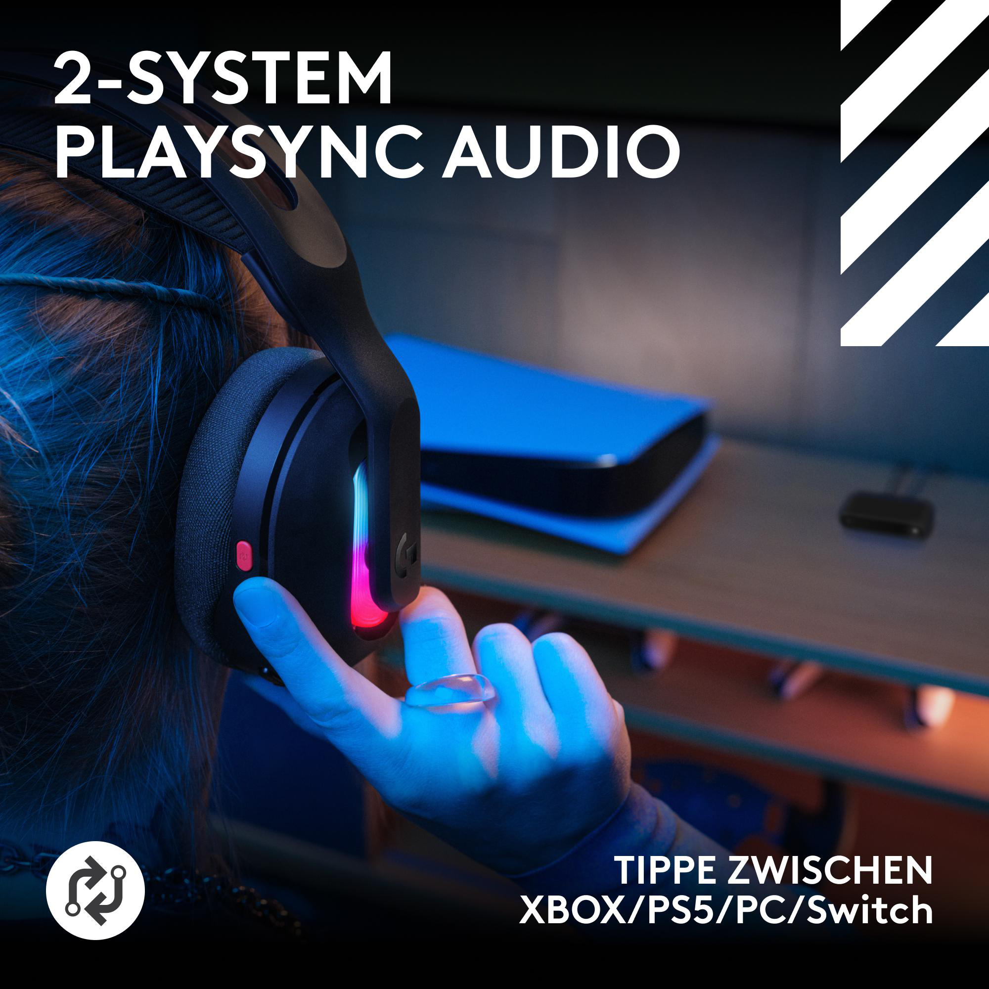 Eine Person trägt schwarze Kopfhörer. Im Hintergrund ist ein blaues Objekt zu sehen, mit dem Text '2-System Playsync Audio'.