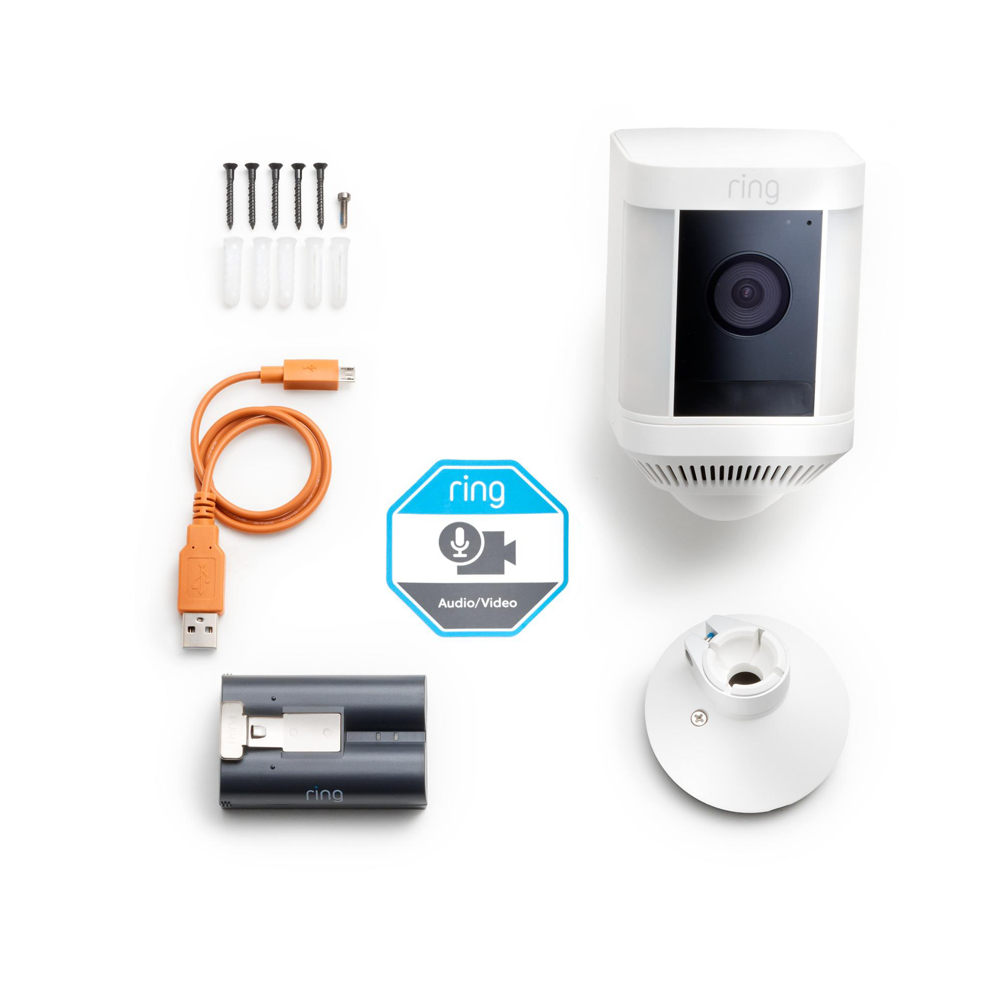 Ring-Sicherheitskamera-Kit mit Komponenten: Schrauben, Kabel, Akku und Montagebasis, alles auf weißer Oberfläche.