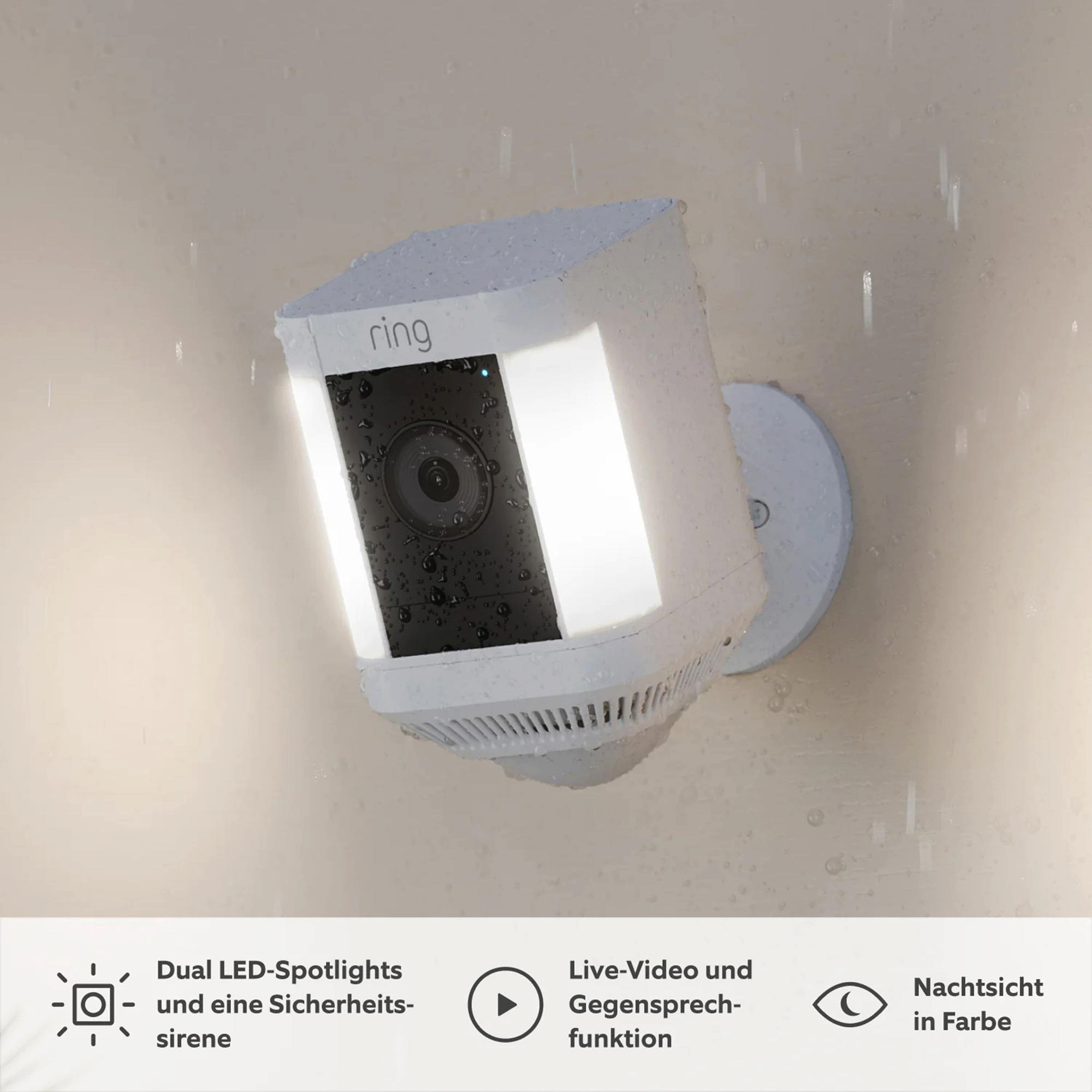 Weiße Ring-Sicherheitskamera. Sie verfügt über LED-Scheinwerfer, Live-Video und Nachtsicht. Die Kamera ist an einer Wand montiert und es regnet.