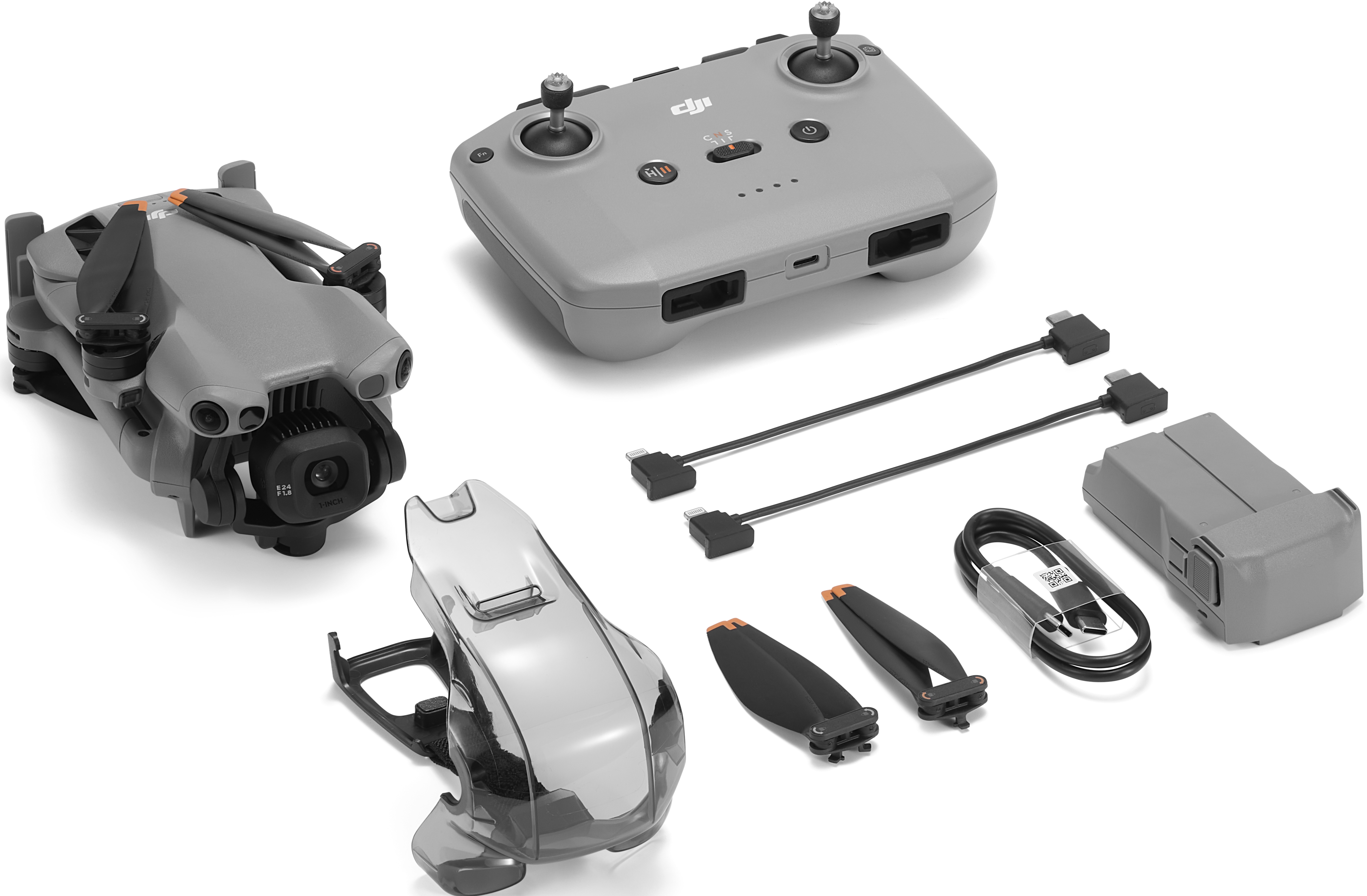 Un drone grigio, controller, cavi, eliche, batteria e una copertura trasparente su sfondo bianco.