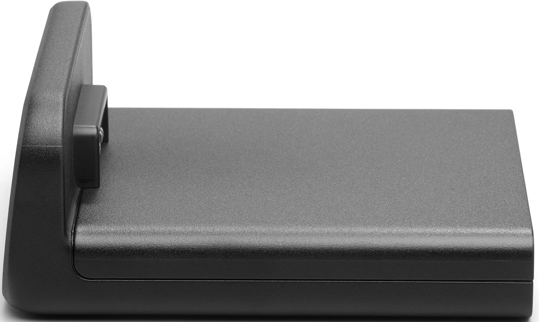 Un appareil noir rectangulaire avec un dos surélevé et une petite projection rectangulaire. Il est posé sur une surface blanche.
