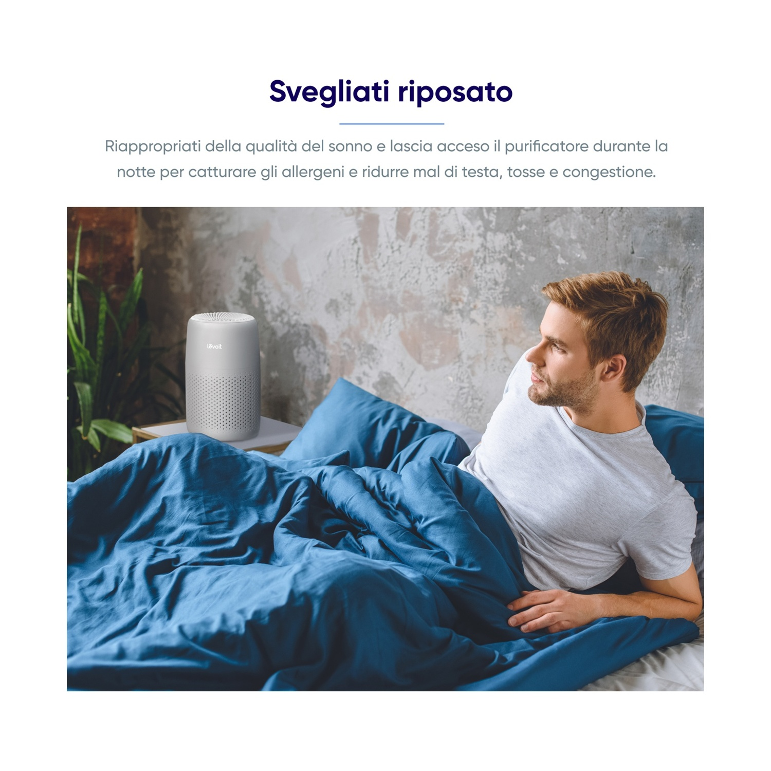 Un uomo a letto guarda un purificatore d'aria bianco. Il letto ha lenzuola blu e un cuscino grigio. Testo in italiano sopra.