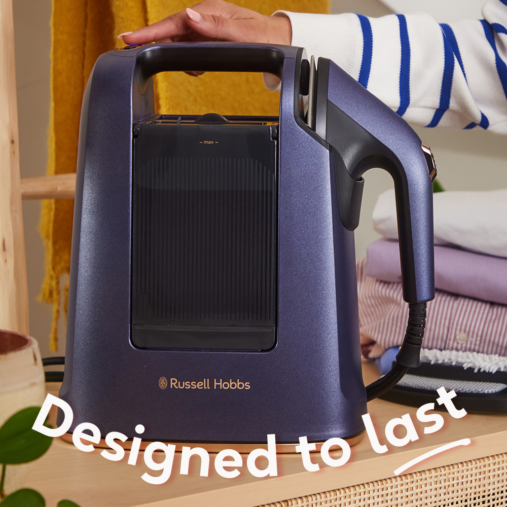 Egy lila Russell Hobbs gőzölő, kéz a tetején. Rakott, összehajtott ruhák a háttérben. A szöveg: Úgy tervezték, hogy tartson.