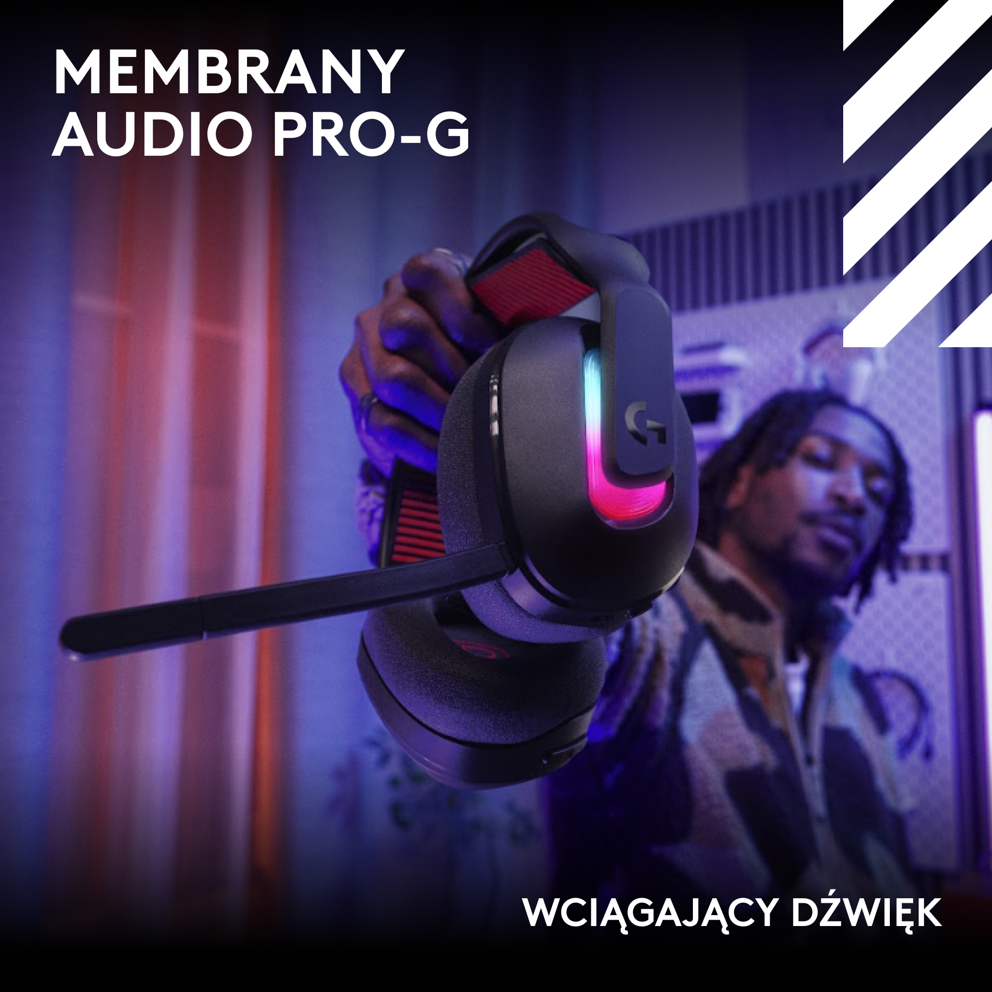 Osoba trzyma czarny zestaw słuchawkowy do gier z czerwonymi akcentami. Mężczyzna w tle.