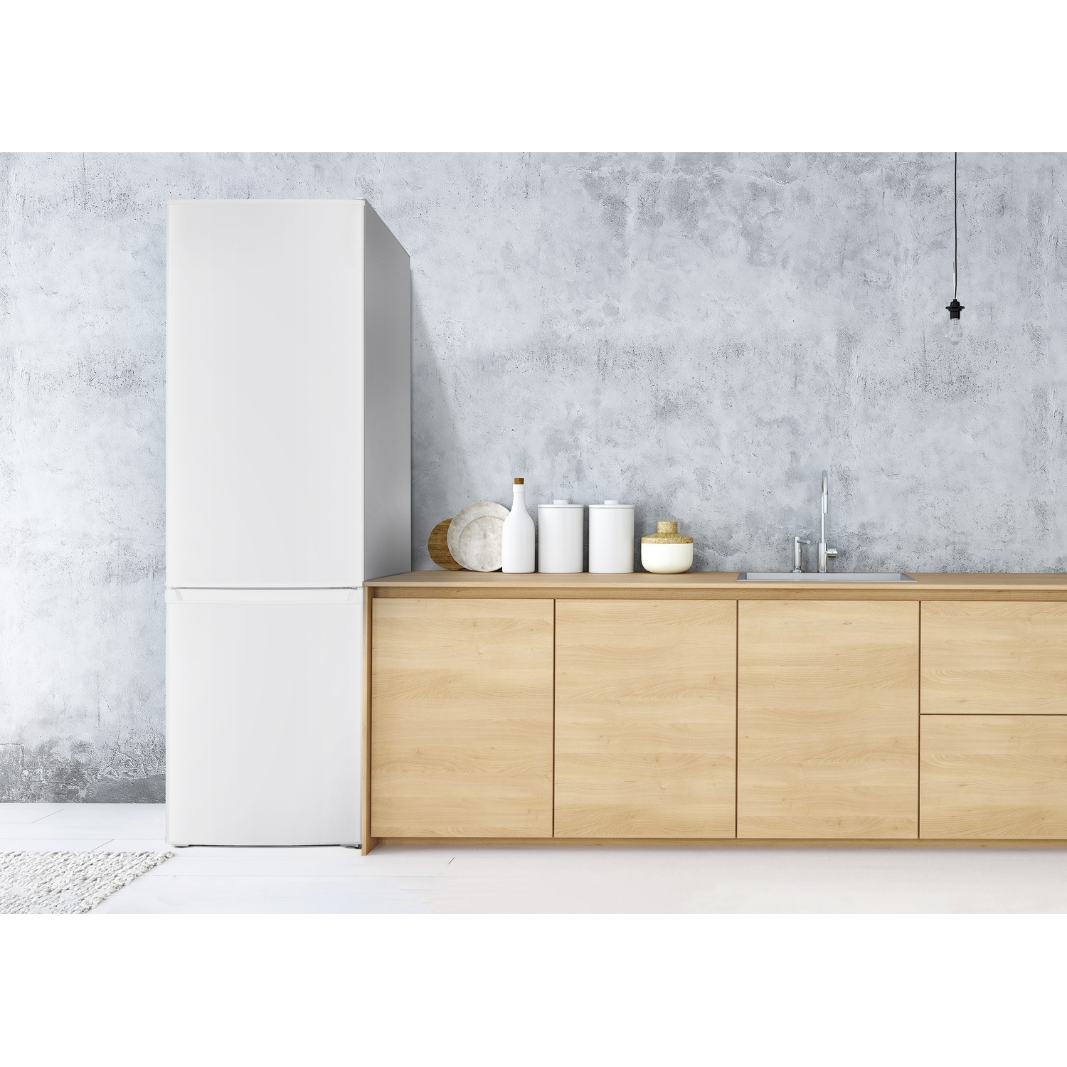 Una cucina moderna con frigorifero bianco, mobili in legno e parete in cemento grigio. Vari utensili da cucina sul bancone.