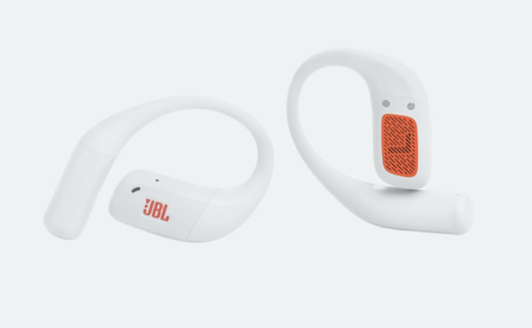 Dwa białe słuchawki JBL. Jedna z czerwonym logo JBL. Pomarańczowe akcenty na słuchawce. Tło jest jednolicie białe.