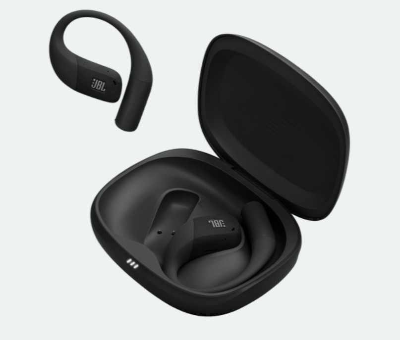 Czarne słuchawki JBL, jedna osobno, dwie w otwartym etui. Etui jest czarne, słuchawki mają konstrukcję z haczykiem. Białe tło.