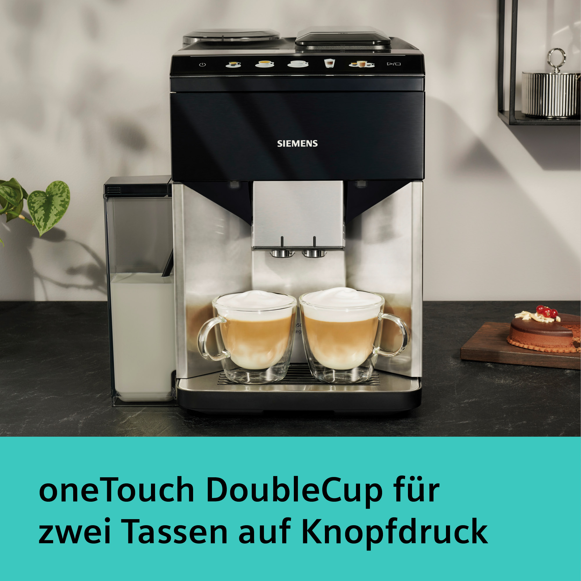 Eine schwarze Siemens-Kaffeemaschine mit zwei klaren Glasbechern Latte. Milchbehälter links, Kuchen rechts.