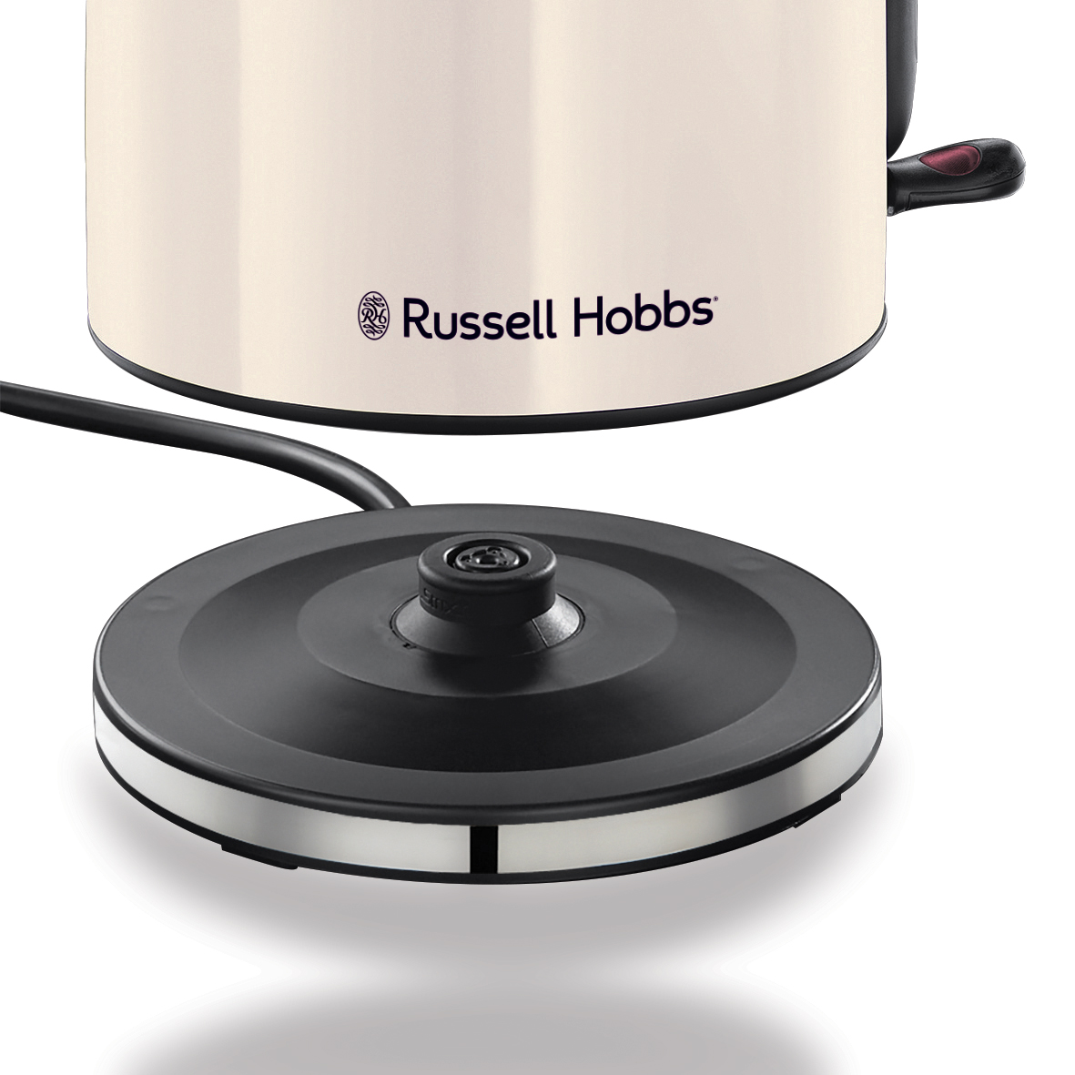 Krémszínű Russell Hobbs vízforraló fekete alappal. Az alap külön van. A vízforralón piros gomb van a fogantyún.