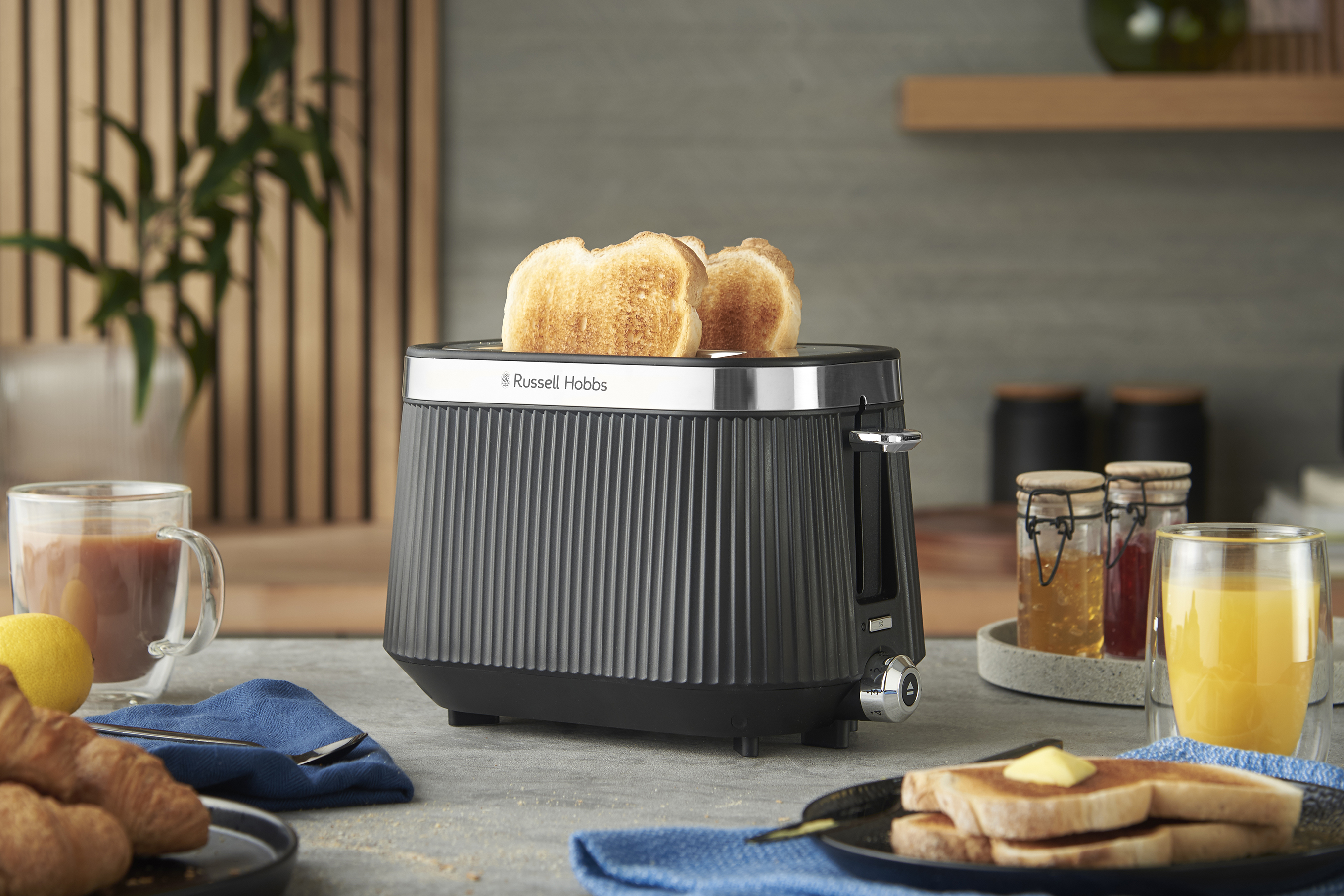 Pirítós kenyérrel, reggeli beállítás gyümölcslével, kávéval, croissant-okkal és lekvárokkal.