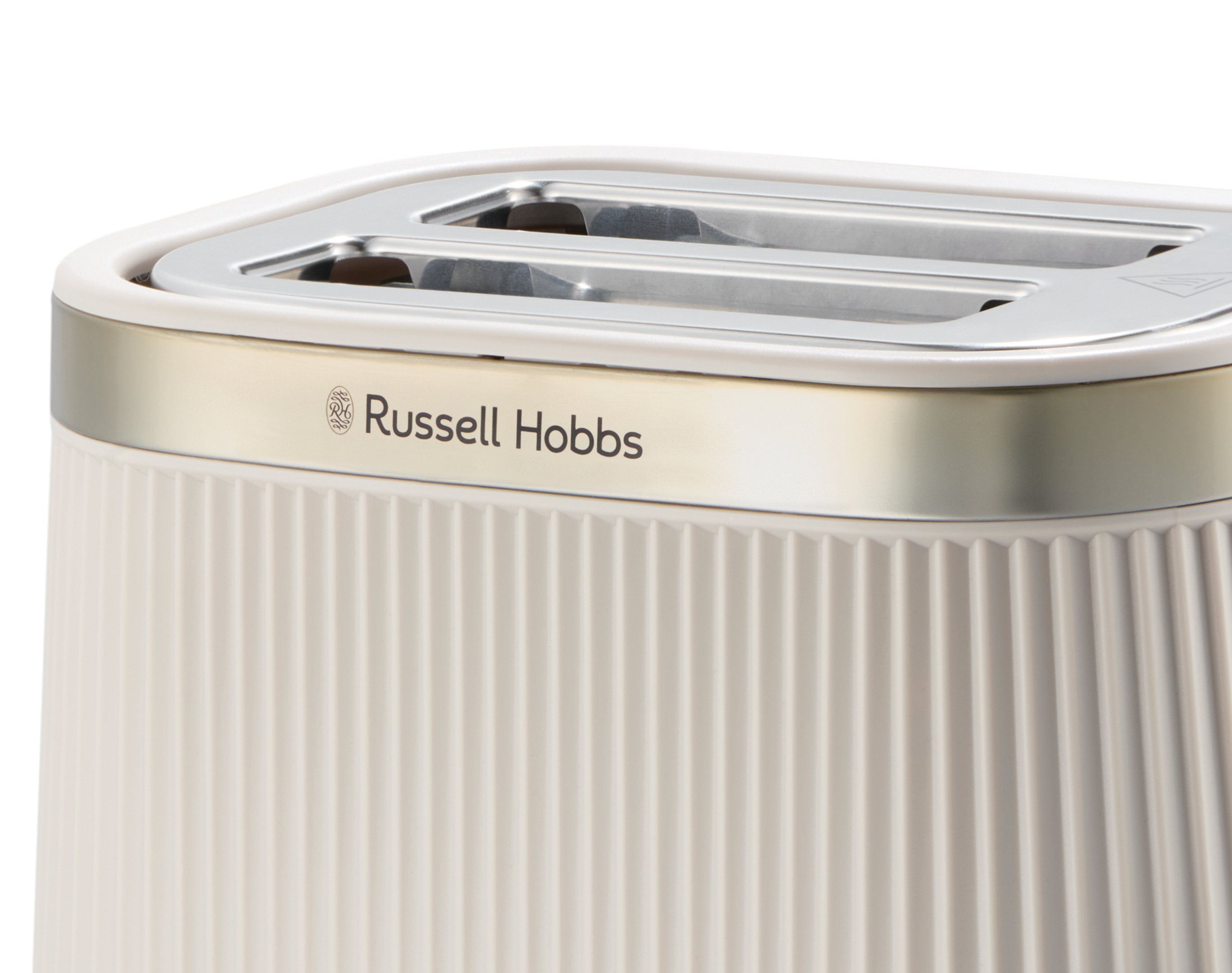 Közeli kép egy krémszínű Russell Hobbs kenyérpirítóról. Függőleges barázdái és ezüst teteje van.