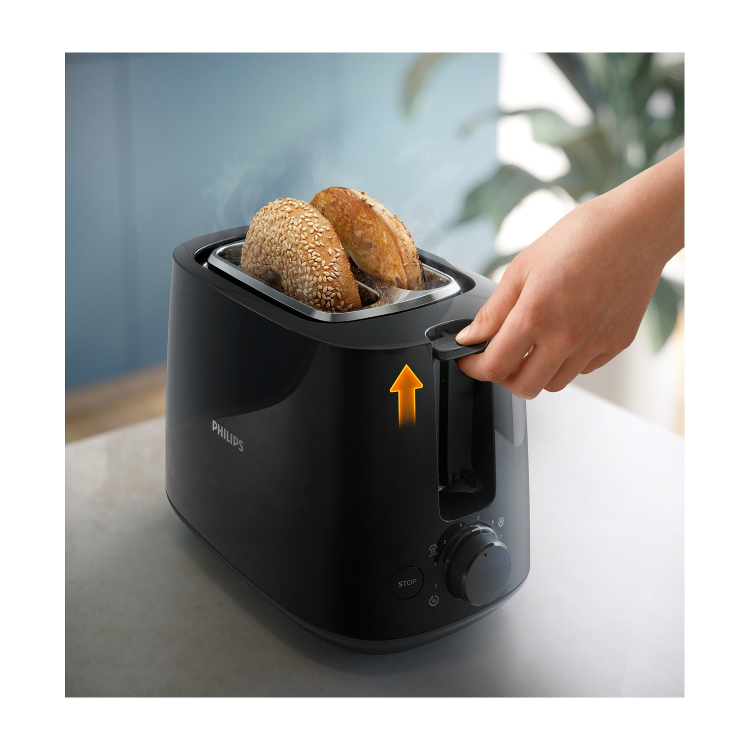Un tostapane Philips nero con due bagel tostati. Una mano tira la leva. Il vapore sale dai bagel.
