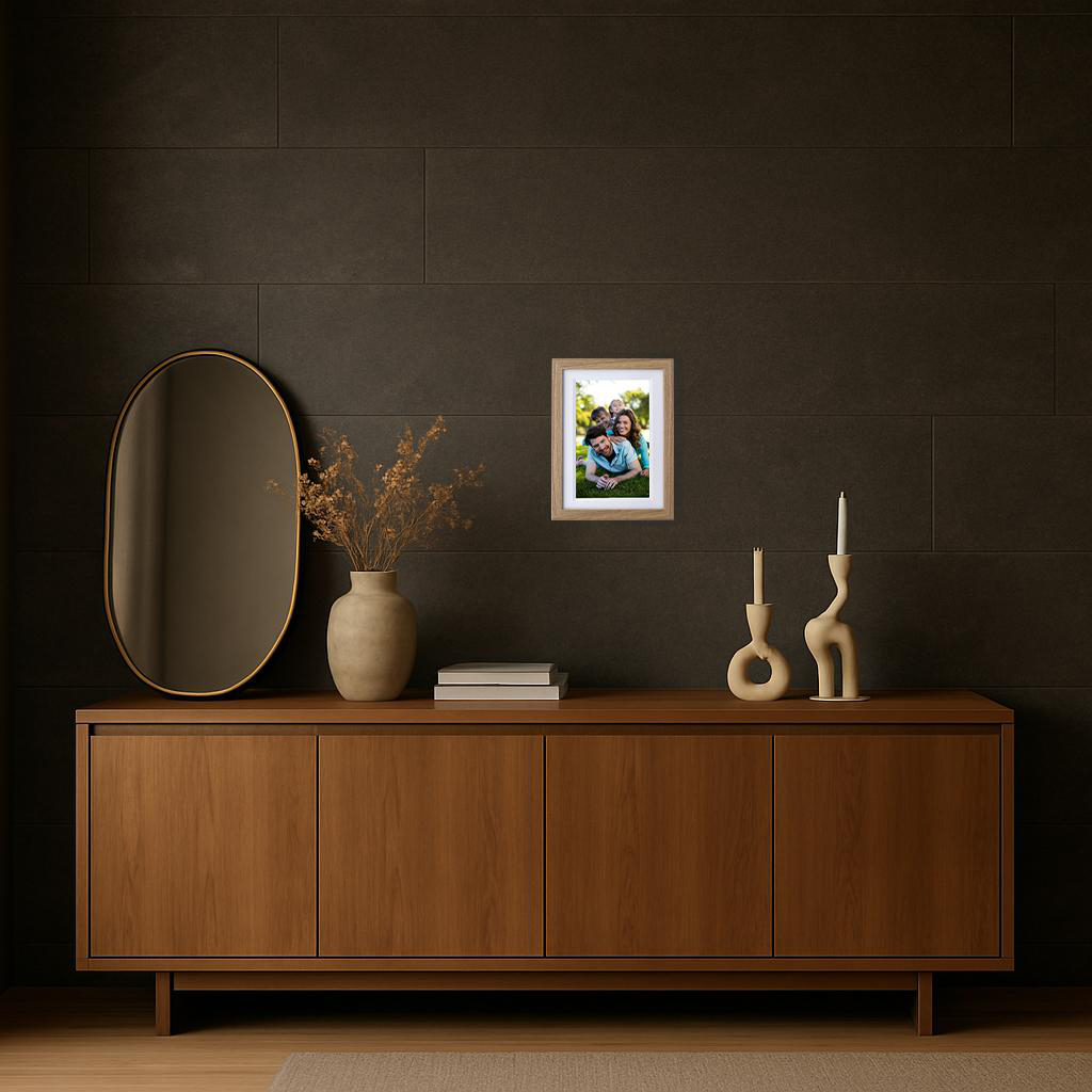 Ein gerahmtes Familienfoto hängt an einer dunklen Wand über einem Holzschrank. Auf dem Schrank befinden sich ein Spiegel, eine Vase und Kerzen.