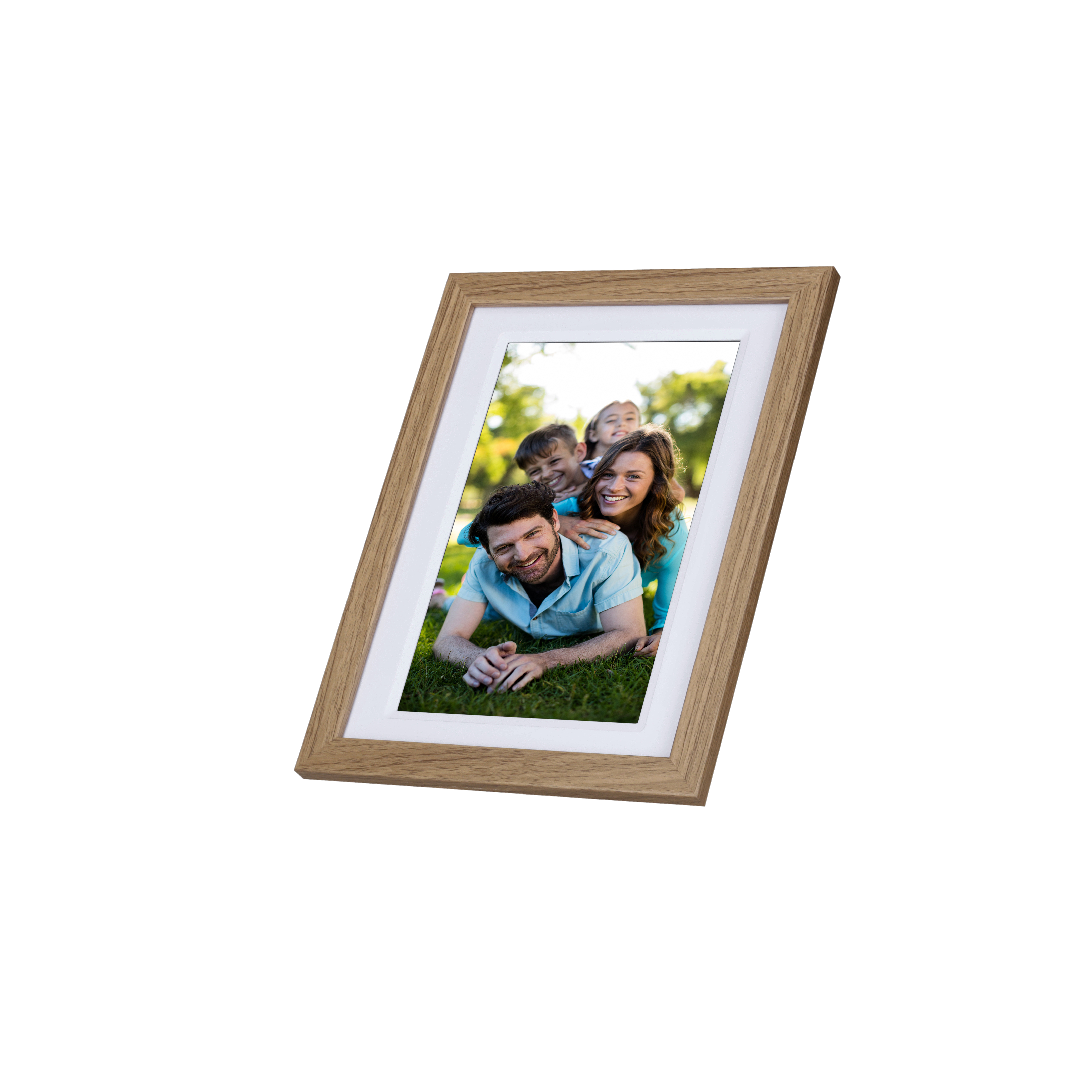 Ein holzgerahmtes Foto einer Familie, die auf Gras liegt. Das Foto ist angewinkelt und auf Weiß isoliert.