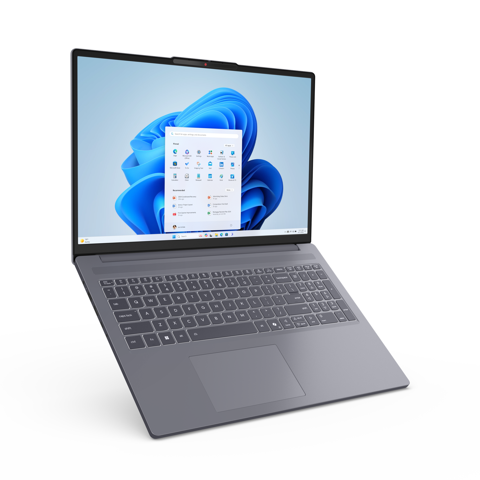Un ordinateur portable gris est ouvert, affichant l'interface Windows 11 avec des icônes d'applications et un fond bleu.