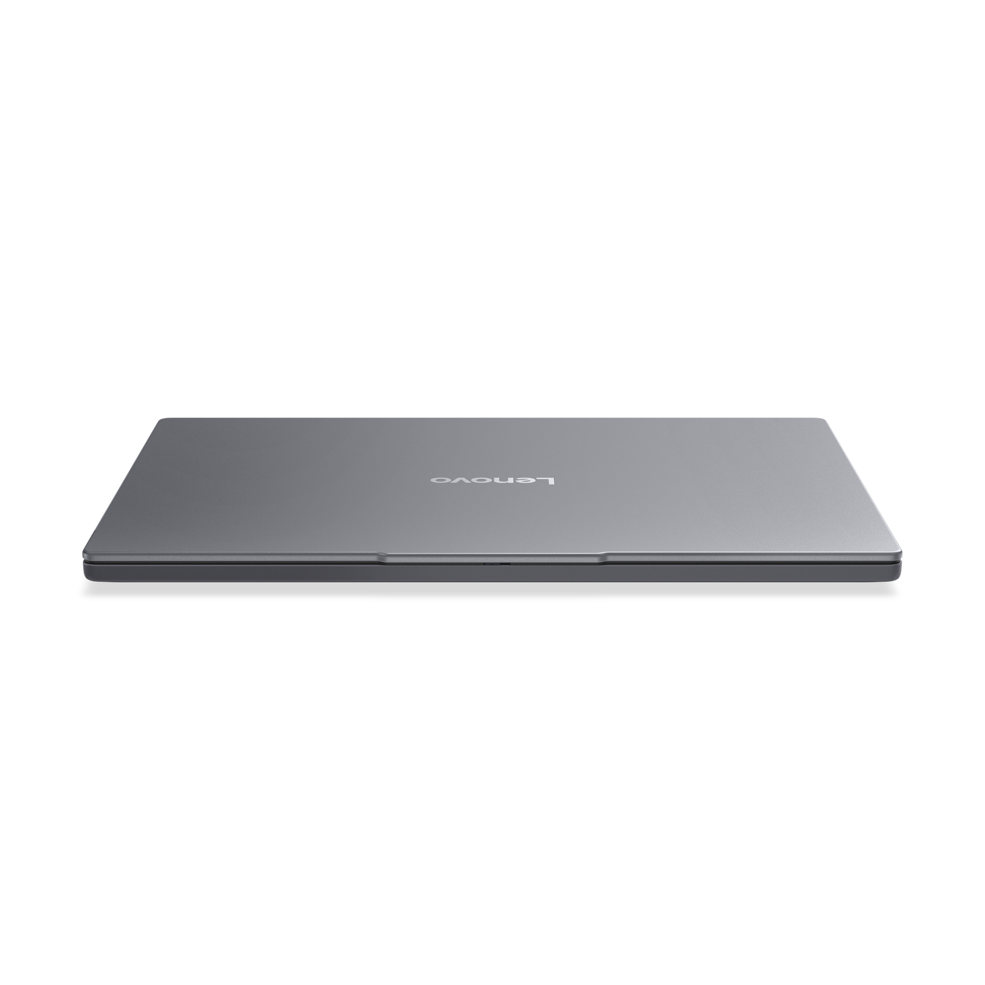 Un ordinateur portable Lenovo gris fermé sur fond noir. Le logo Lenovo est visible en haut.