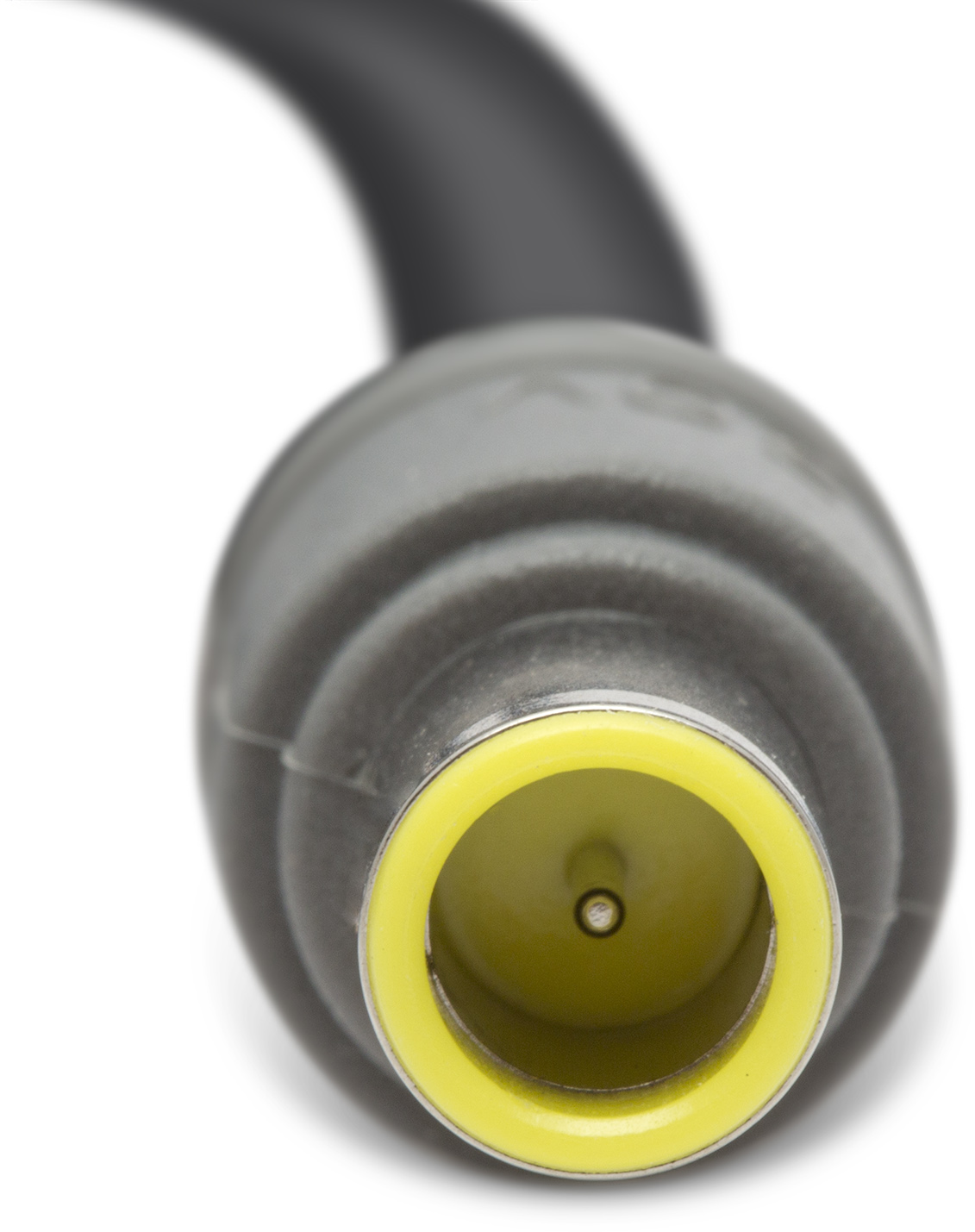 Egy fekete-szürke hálózati adapter közeli képe, sárga belsővel. A kábel fekete és elgörbül az adaptertől.