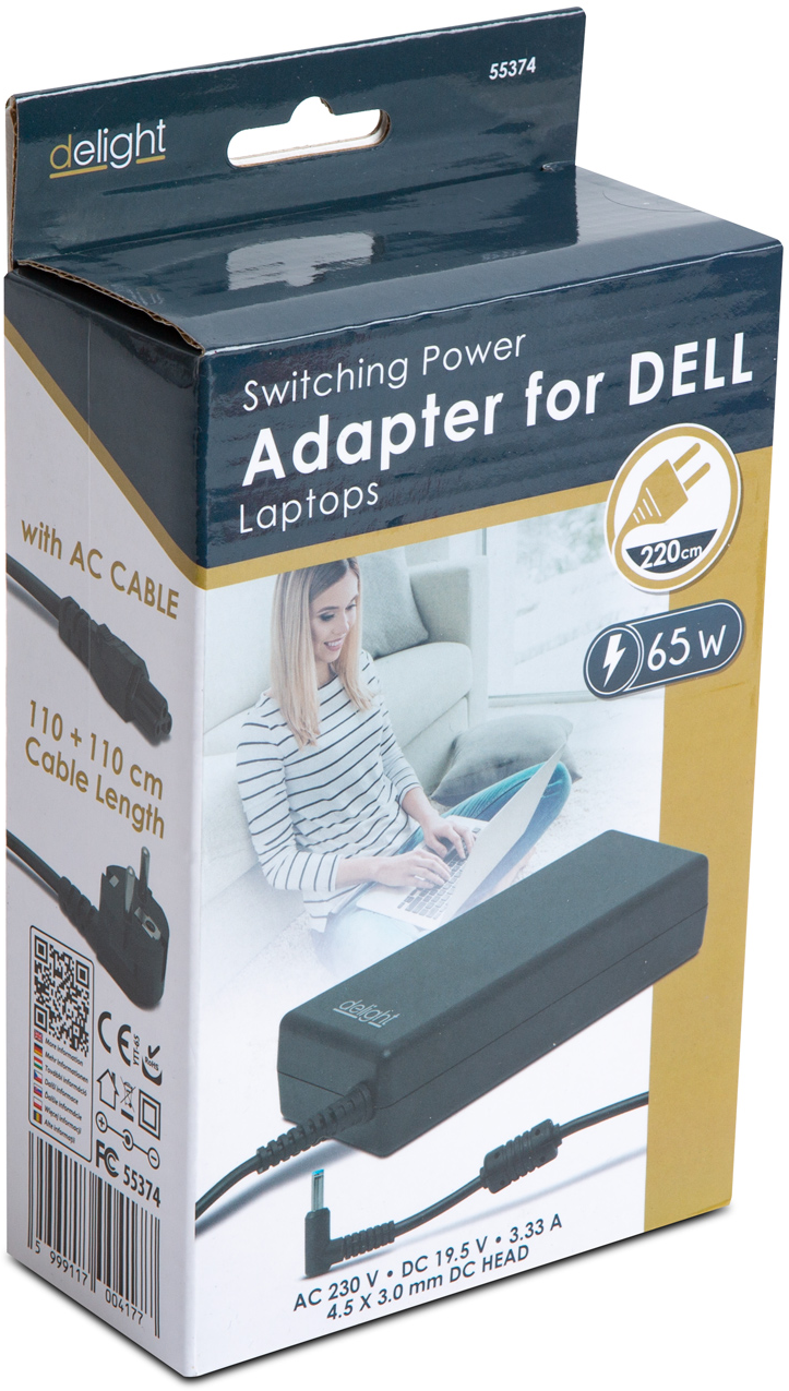 A dobozon egy Dell laptop hálózati adapter látható. Fekete adapterrel, kábelekkel, és egy laptopot használó nővel a háttérben.