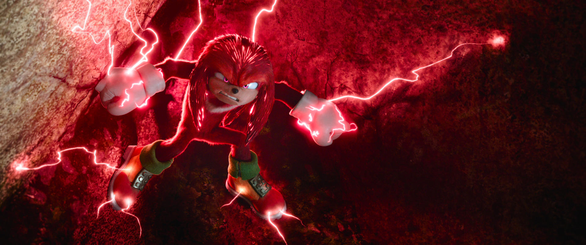 Knuckles, roter Ameisenigel, kommt aus einer felsigen Oberfläche, umgeben von roter Energie. Er ist in Kampfhaltung, mit intensivem Ausdruck.