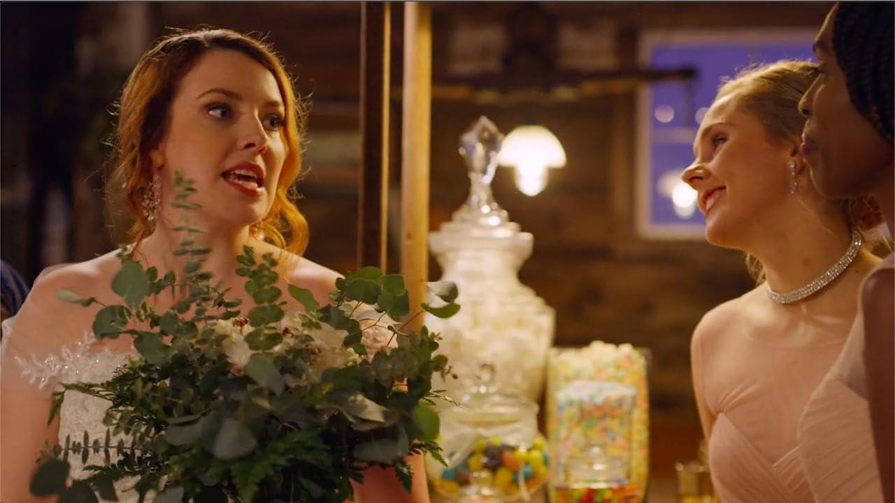 Frau mit Blumenstrauß spricht mit zwei anderen. Einer trägt eine Halskette. Eine Süßigkeiten-Auslage und ein dekoratives Glas stehen im Hintergrund.