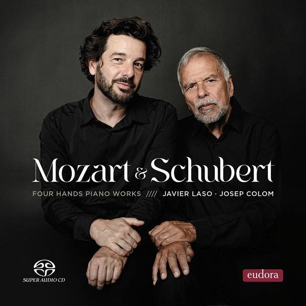 Zwei Männer in schwarzen Hemden, einer bärtig, der andere mit grauem Haar, unter dem Titel „Mozart & Schubert“. Text: Vierhändige Klaviermusik.