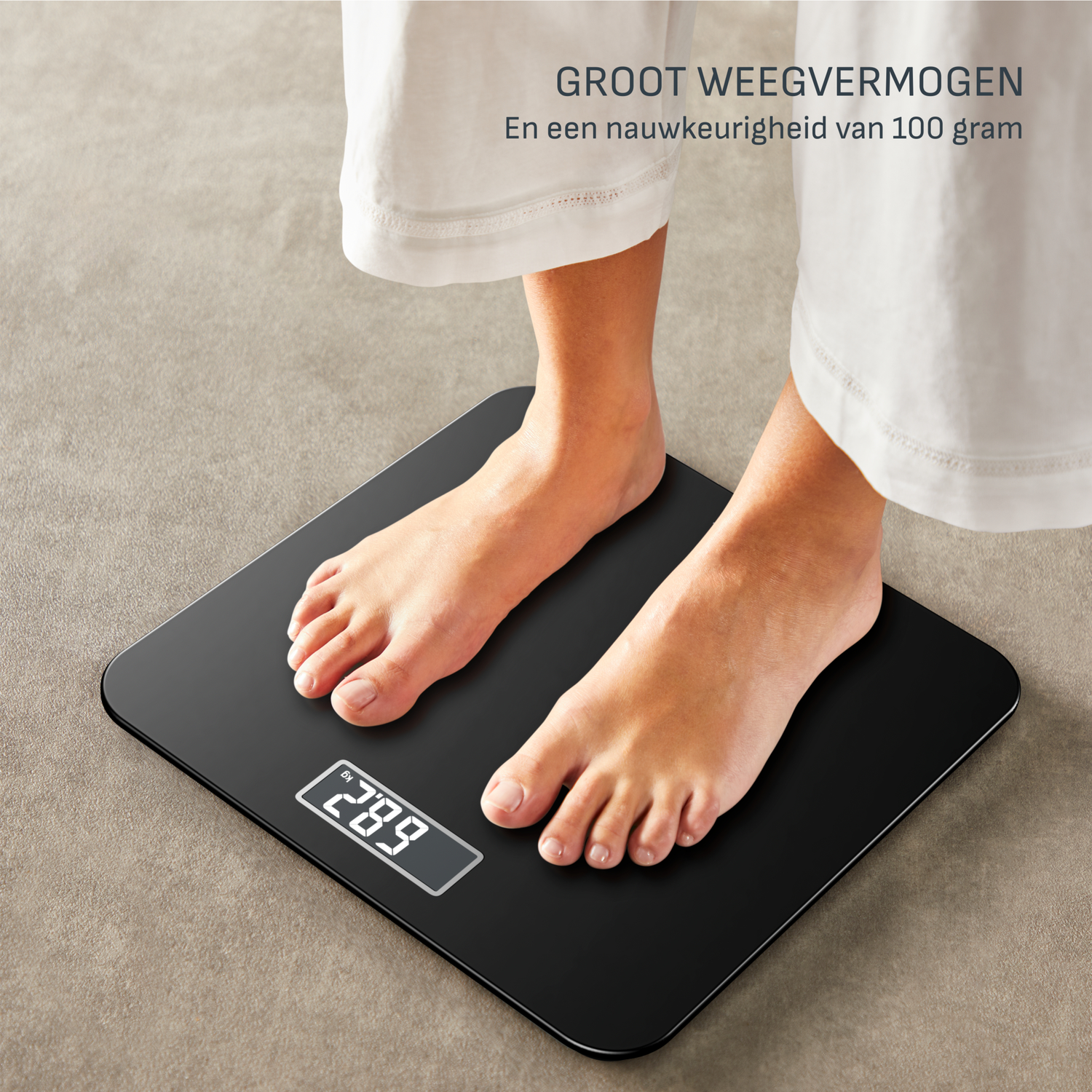 Een persoon staat op een zwarte weegschaal. De weegschaal geeft 68,2 kg aan. De persoon draagt een witte broek.