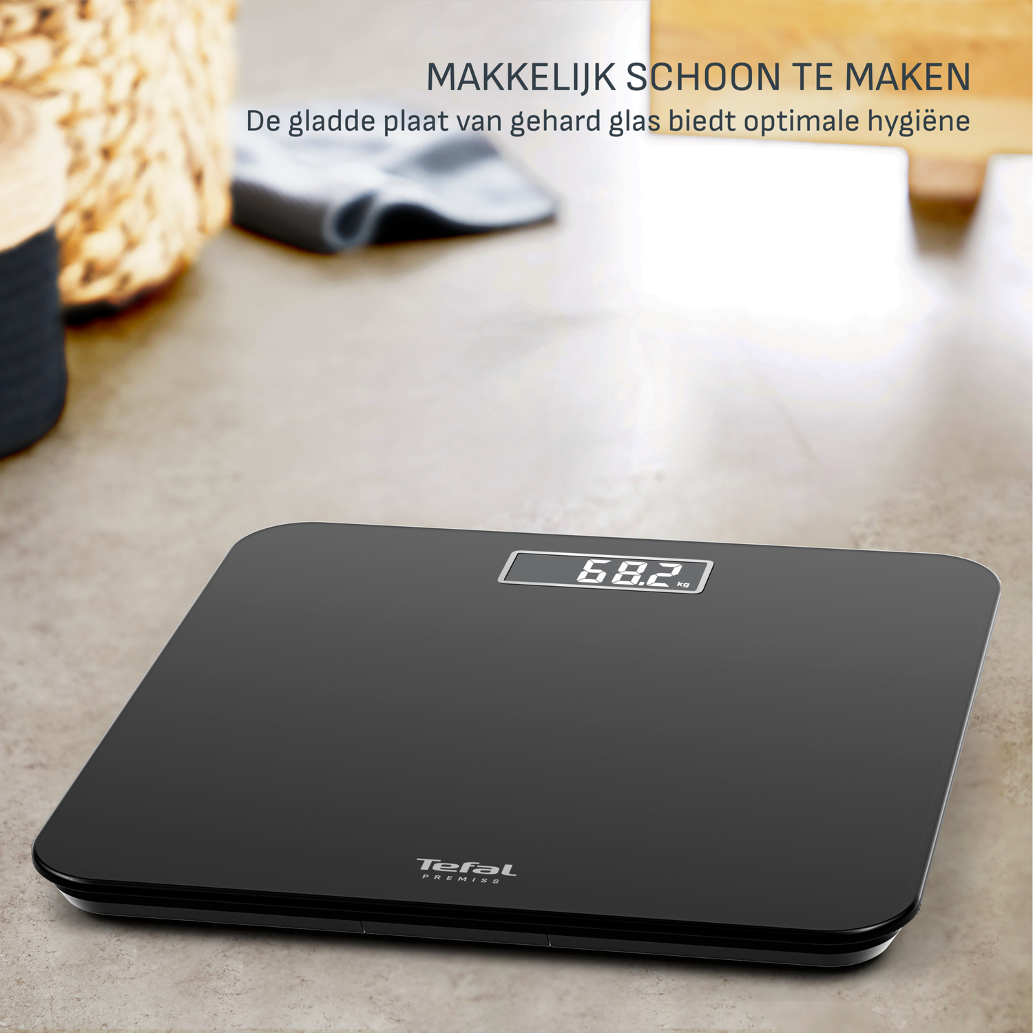 Een zwarte Tefal weegschaal toont 68,2 kg. Tekst: gemakkelijk schoon te maken. Het gladde glasoppervlak biedt optimale hygiëne.