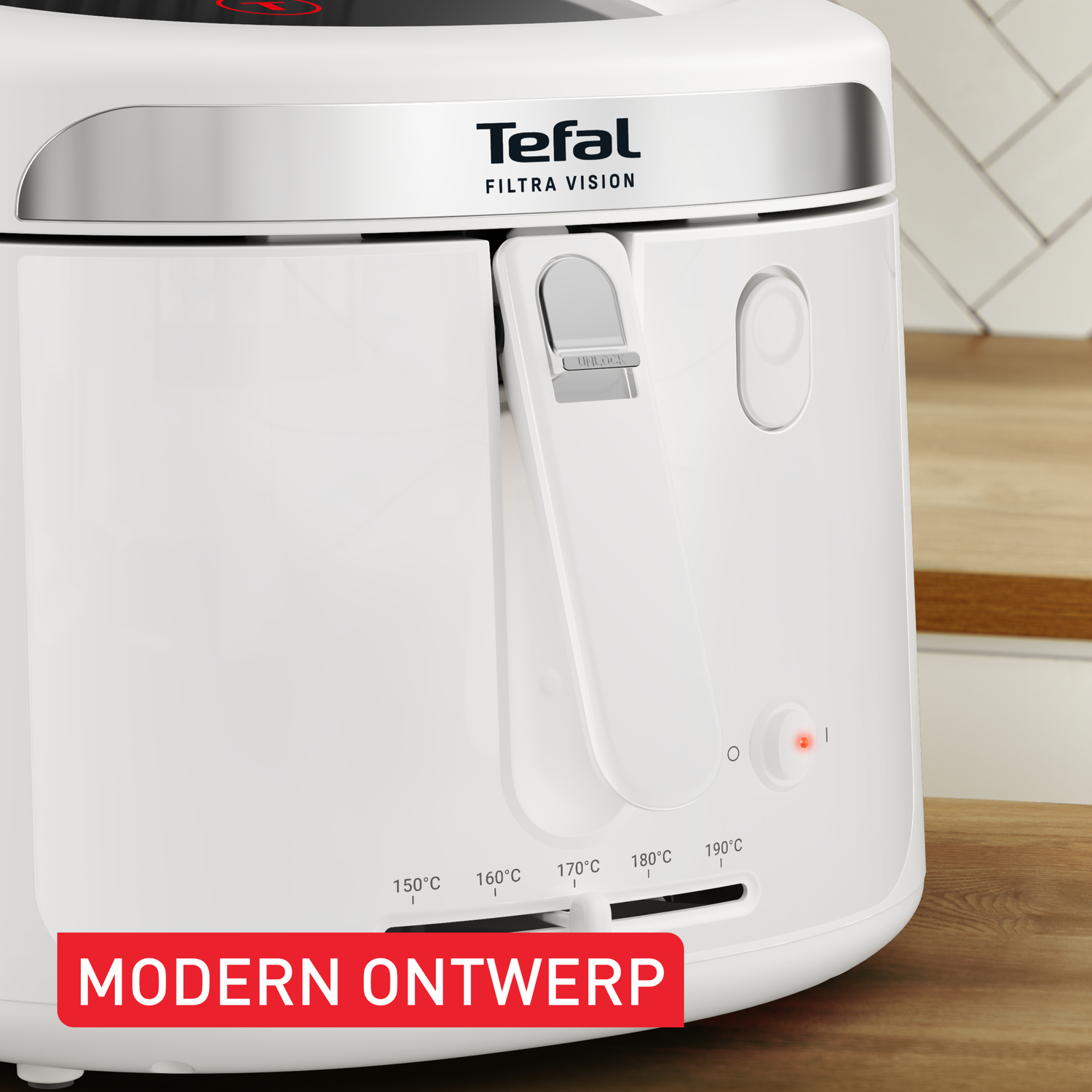 A white Tefal Filtra Vision deep fryer. Features temperature settings and a red power light. The background is blurred, showing a kitchen.