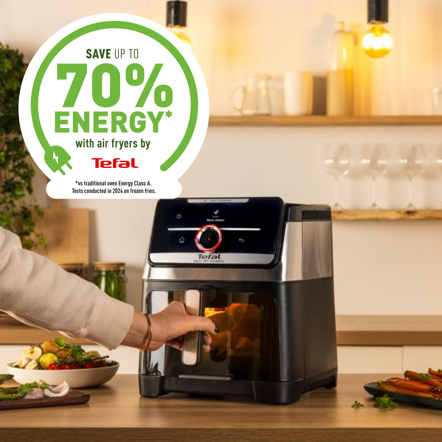 An air fryer is being used in a kitchen. A hand is opening the door. The background shows food and kitchen items.