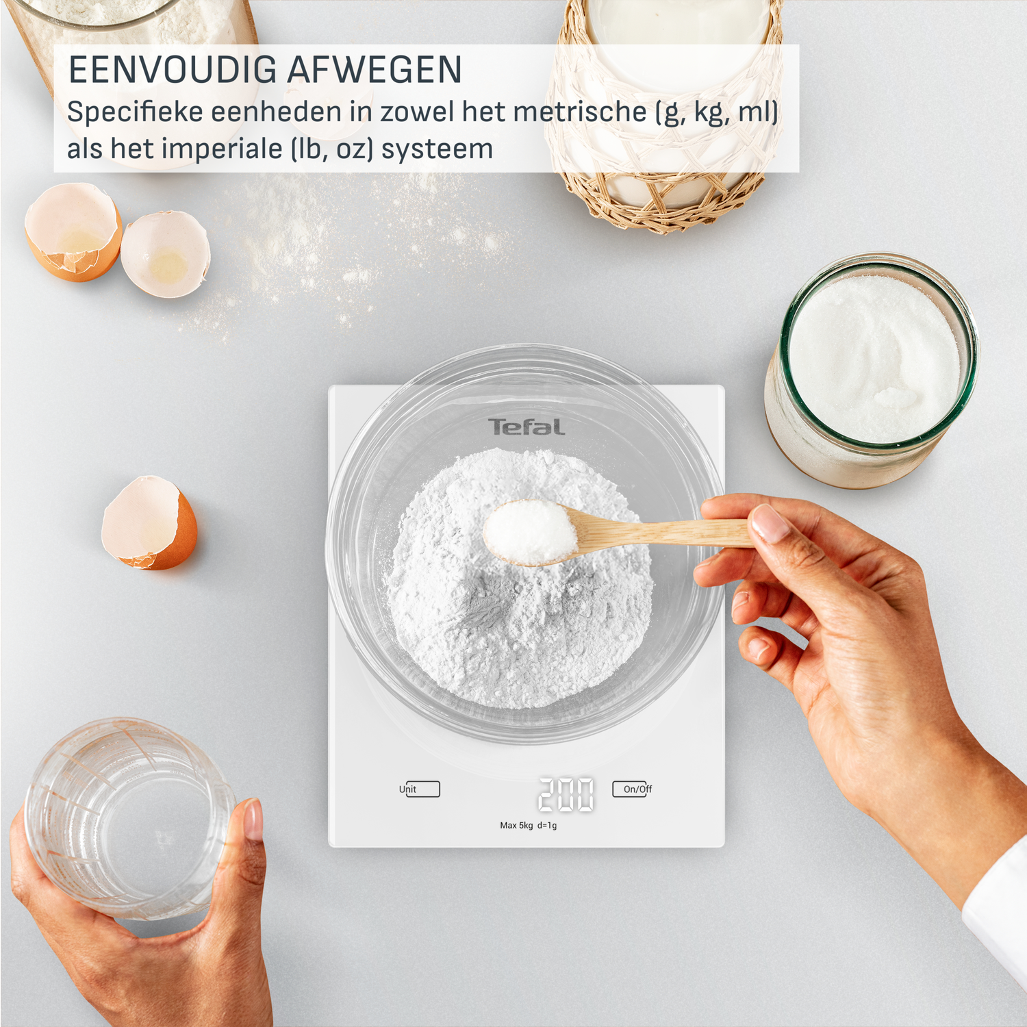 A person is weighing flour on a Tefal scale. Other elements include a glass of water, an eggshell, and a jar of white powder.