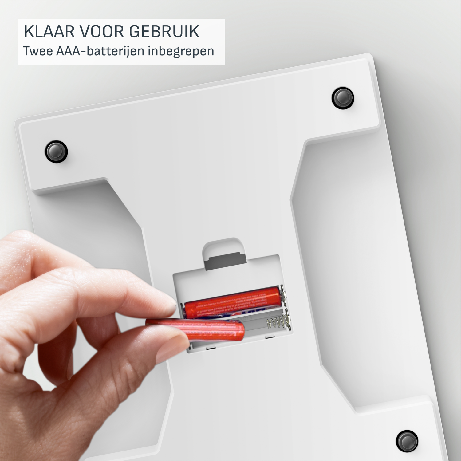 Hand inserts red AAA battery into a white scale's battery compartment. The scale is white, and text at the top says 'READY TO USE'.
