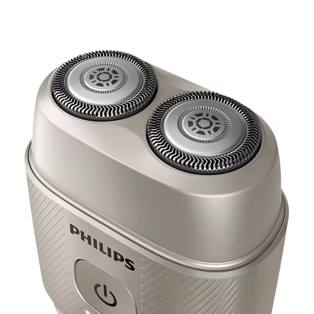 Egy ezüst Philips elektromos borotva két kör alakú borotvafejjel. A be/ki gomb látható. A háttér fehér.